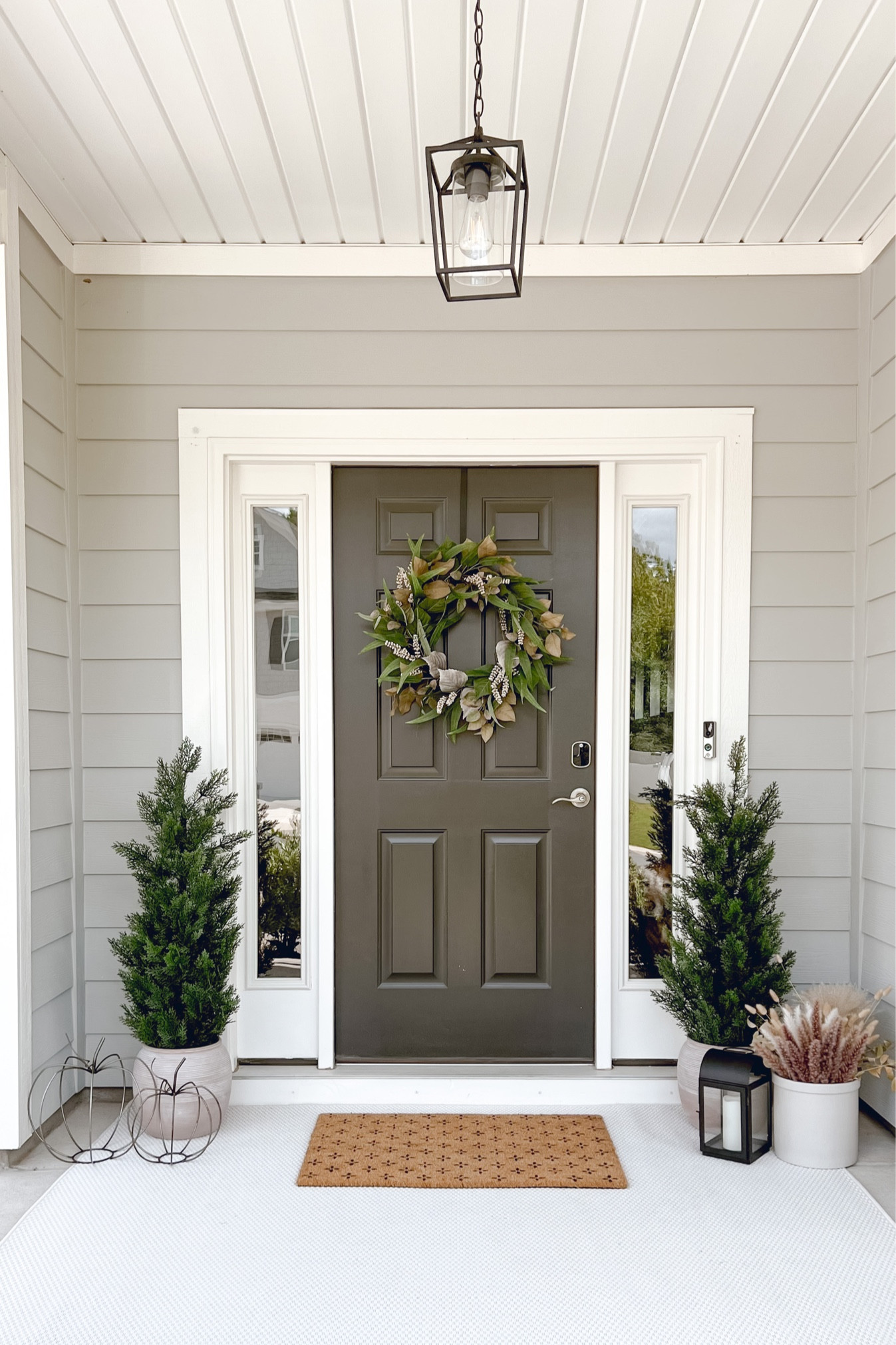 Front porch, outdoor pendant light, dried florals, pots, wreath, front door, door mat, outdoor rug, lanterns, faux trees, faux topiary

#LTKhome #LTKunder100 #LTKSeasonal
