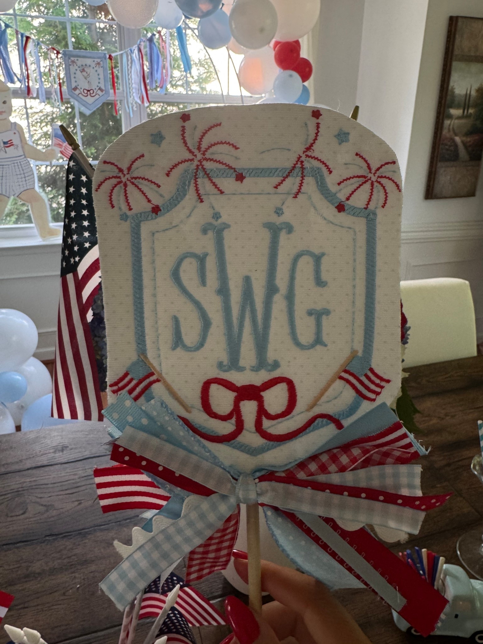 Patriotic cake topper 
You can send her this picture for inspo! And she can customize as needed 