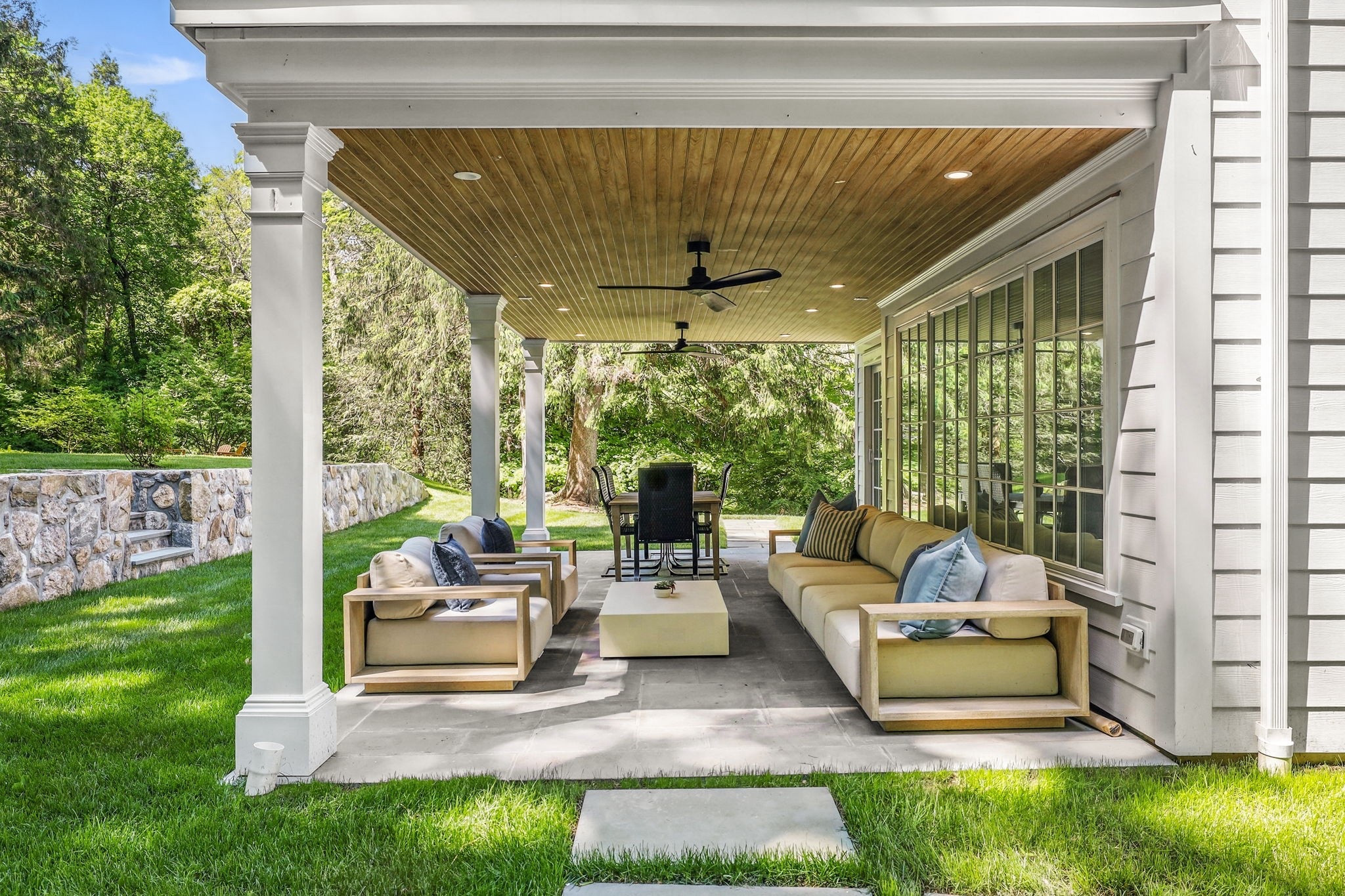 A peaceful retreat tucked beneath the trees. This covered patio offers a comfortable, year-round place to relax, entertain, and take in the beauty of the surrounding landscape.

📷 by Houlihan Lawrence