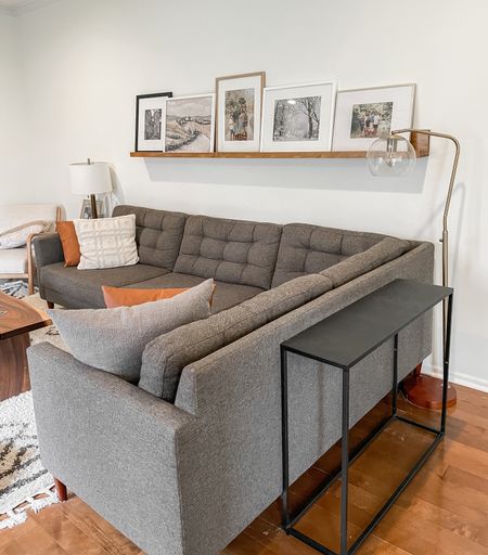 Family room midcentury gray sectional sofa.  Black modern console table.  Target gold modern floor lamp.  Digital Etsy art.  Collection Prints downloadable art.  Rugs USA Moroccan area rug.  

#LTKhome #LTKFind #LTKfamily