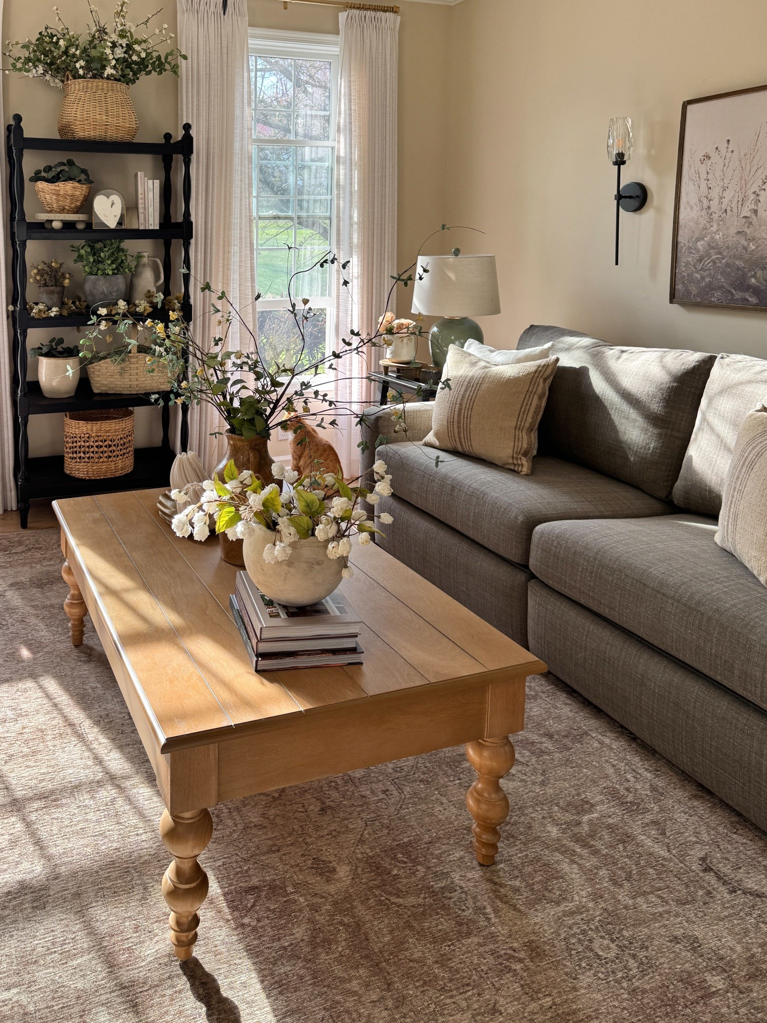 Living room styling:

Coffee table -currently 65% off! 
Neutral area rug
Electric wall sconces
Neutral wooden wall art
Coffee table books
Hops stems
White planter
Black tall book shelf
Similar green lamps
Solid wood end table 
Pillow cushions

Sofa is from Best Home Furnishings - unable to link   

#LTKHome