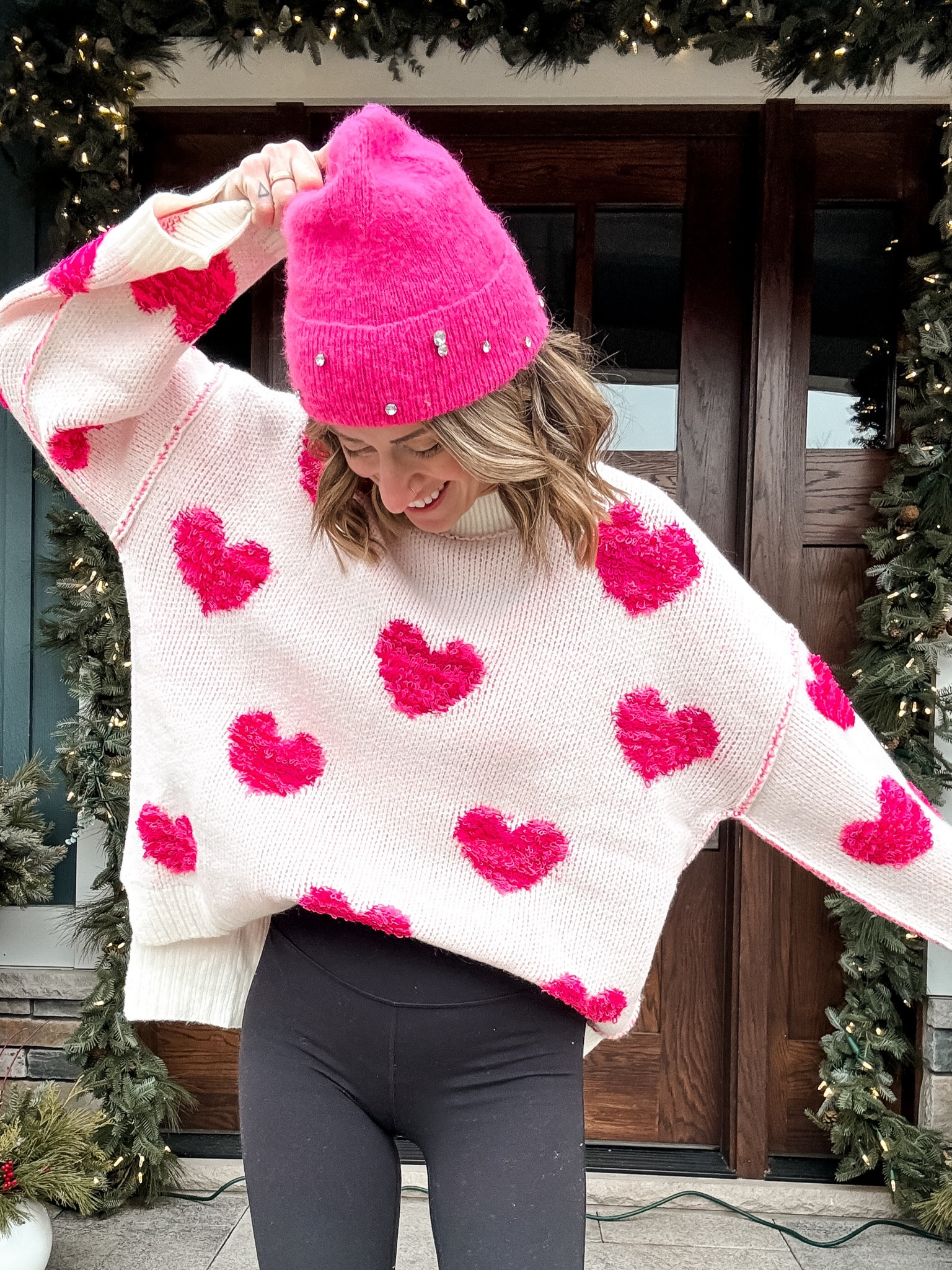 Valentine’s Day style cozy, white oversize sweater, heart print sweater, pink girly style outfits with leggings red dress boutique valentines outfits #rdbabe