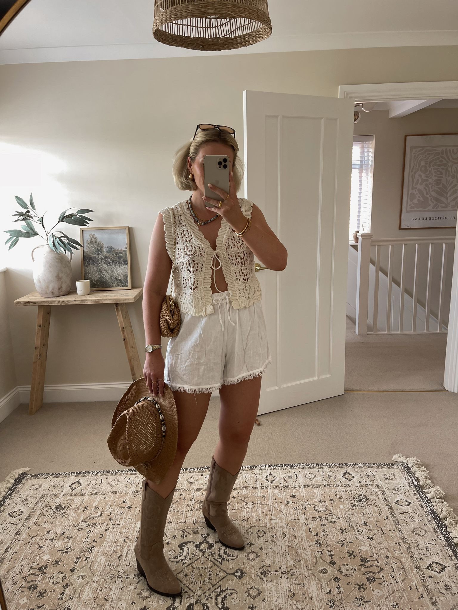Chic summer festival & Ibiza outfit ideas - asos crochet cream waistcoat, H&M white linen fringe trim shorts, raffia cowboy hat, Carrie Elizabeth blue bead necklace, Vehla sunglasses, mango raffia clutch bag, beige suede cowboy boots 

#LTKuk #LTKsummer #LTKstyletip