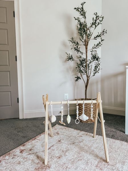 Baby girl nursery decor // wooden baby play gym - faux olive tree - woven basket - light pink rug 

#LTKhome #LTKbaby #LTKbump