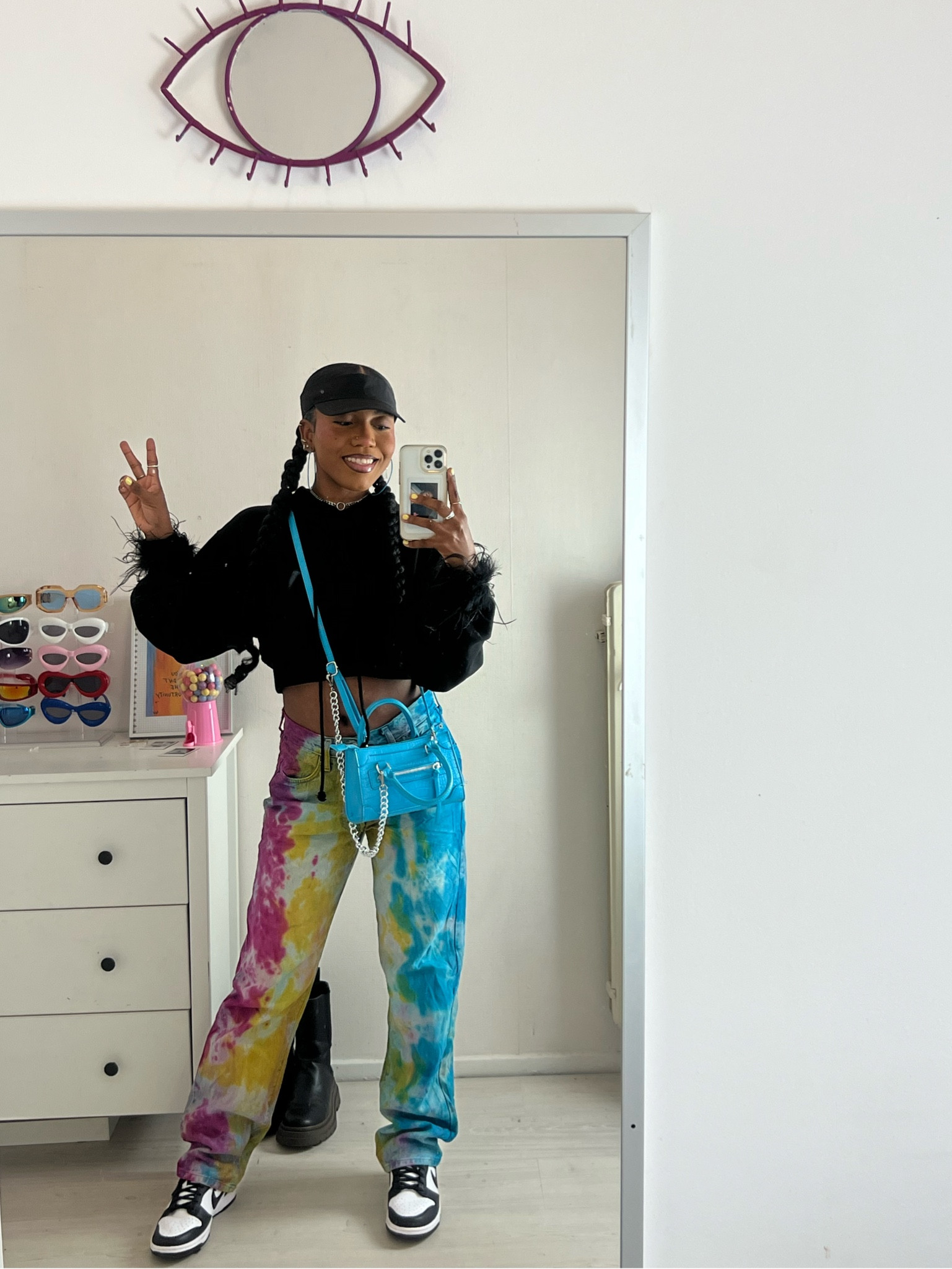 Festival outfit. Black hoodie. Tie dye pants. Festival fashion. Colorful pants. Blue bag. Black tennis cap. Half cap. Feather bracelets. Oversized pants. Cropped hoodie. Nike dunk low panda. Nike sneakers. Blue accessories. Bratz outfit. 

#LTKFind #LTKeurope #LTKstyletip