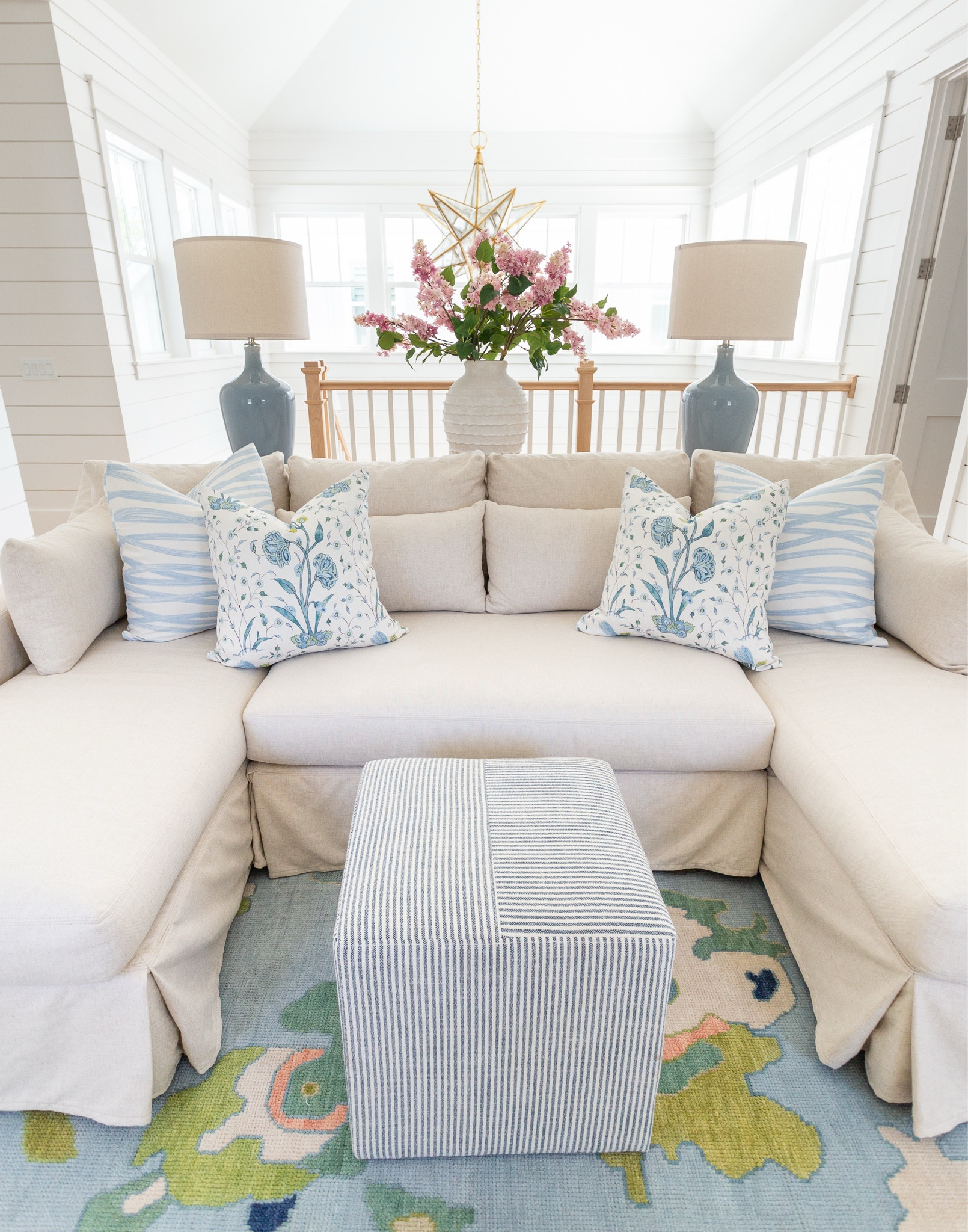 Our loft living room decorated for spring! I used these pink lilac stems, ribbed white vase, colorful oushak rug, linen sectional, light wood console table, blue lamps, striped ottoman cube, brushstroke throw pillow and floral pillow for pops of spring. See our full spring home tour here: https://lifeonvirginiastreet.com/2024-spring-home-tour/
.
#ltkhome #ltksalealert #ltkfindsunder50 #ltkfindsunder100 #ltkstyletip #ltkseasonal spring living room, sectional styling, colorful spring decor

#LTKSeasonal #LTKSaleAlert #LTKHome