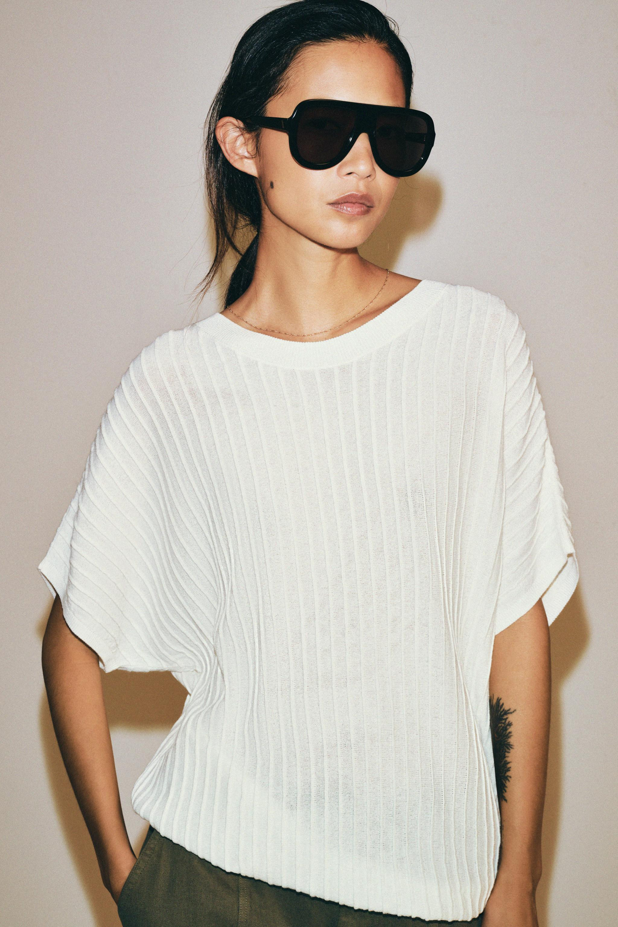 Flowy top with a round neck and short sleeves. Features textured vertical striped fabric. | Zara US