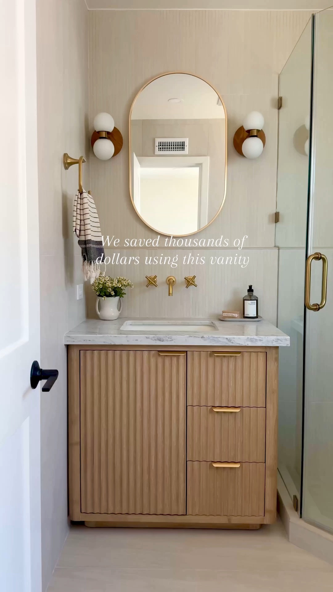 Can you believe this vanity isn't custom? It has
organized compartments in the drawer, soft close, and the prettiest wood fluted detail. Comes with a countertop and without. This entire bathroom is from Wayfair.

Brass hardware wood vanity white tile grey tile brass shower system bathroom accessories medicine cabinet black rectangle mirror oval capsule sconces lights

#LTKSaleAlert #LTKHome