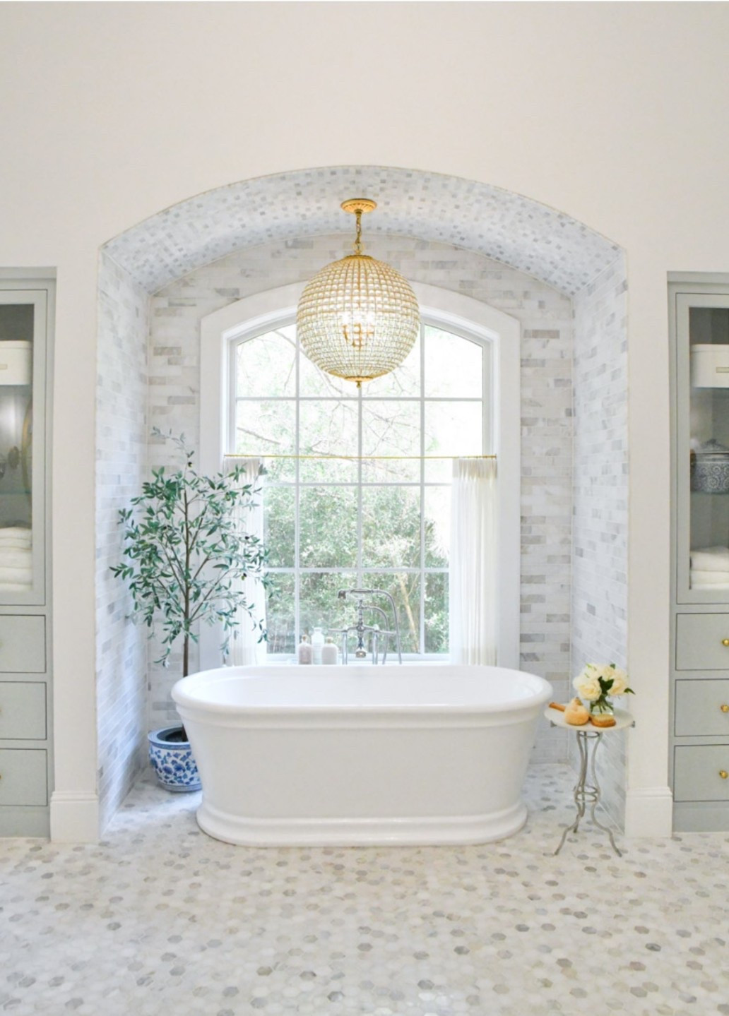 Primary bathroom
Chandelier, tub faucet, olive tree, blue and white planter 

#LTKHome