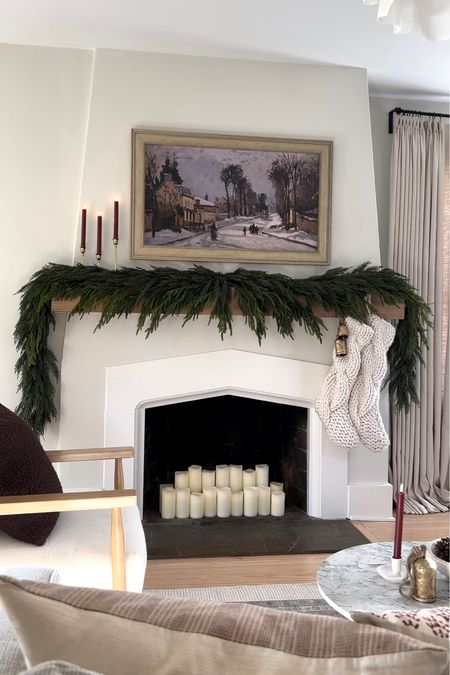 Fireplace mantel decorated for the holidays with two types of garland, knit stockings, flameless candles, and bells. 🌲❤️#christmasdecor #holidaydecor 

#LTKHoliday #LTKhome #LTKSeasonal