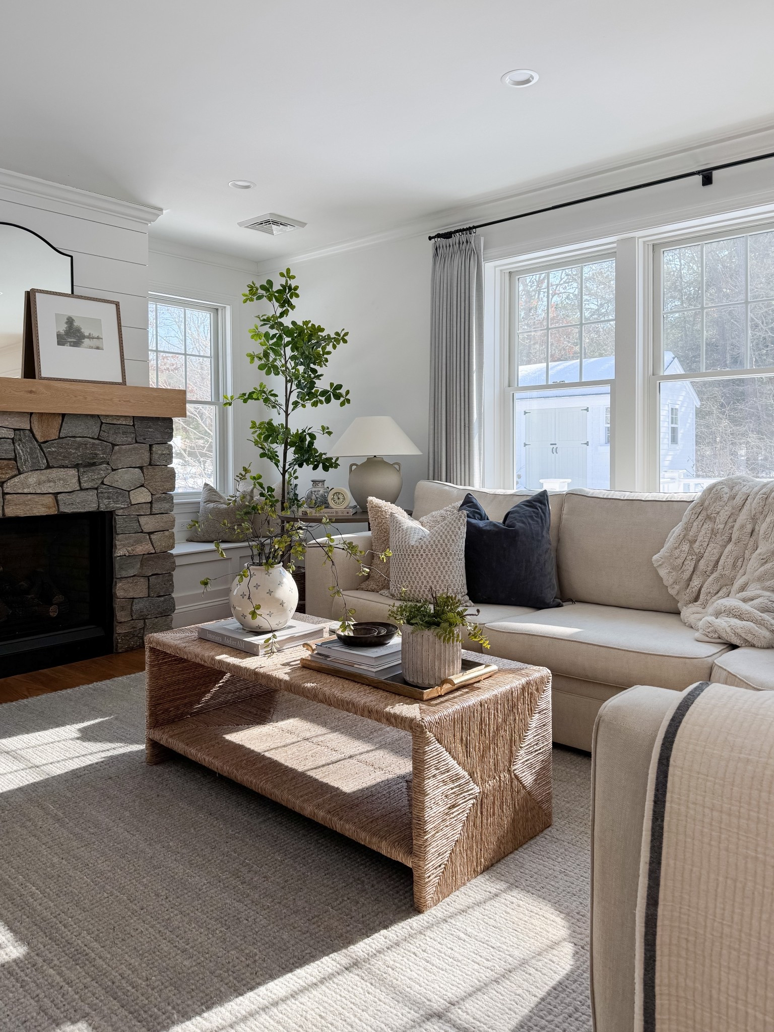 Bright neutral living room with woven coffee table, ceramic vase with greenery branches, linen drapery panels, and soft textured pillows. Natural light, organic materials, and warm wood tones bring a relaxed coastal feel. 
woven coffee table, neutral coastal decor, linen curtains, living room inspiration, spring home refresh, natural textures, ceramic vase decor, greenery stems, light filled living room, warm wood tones, coastal style, organic modern, sherri calnan home

#LTKHome