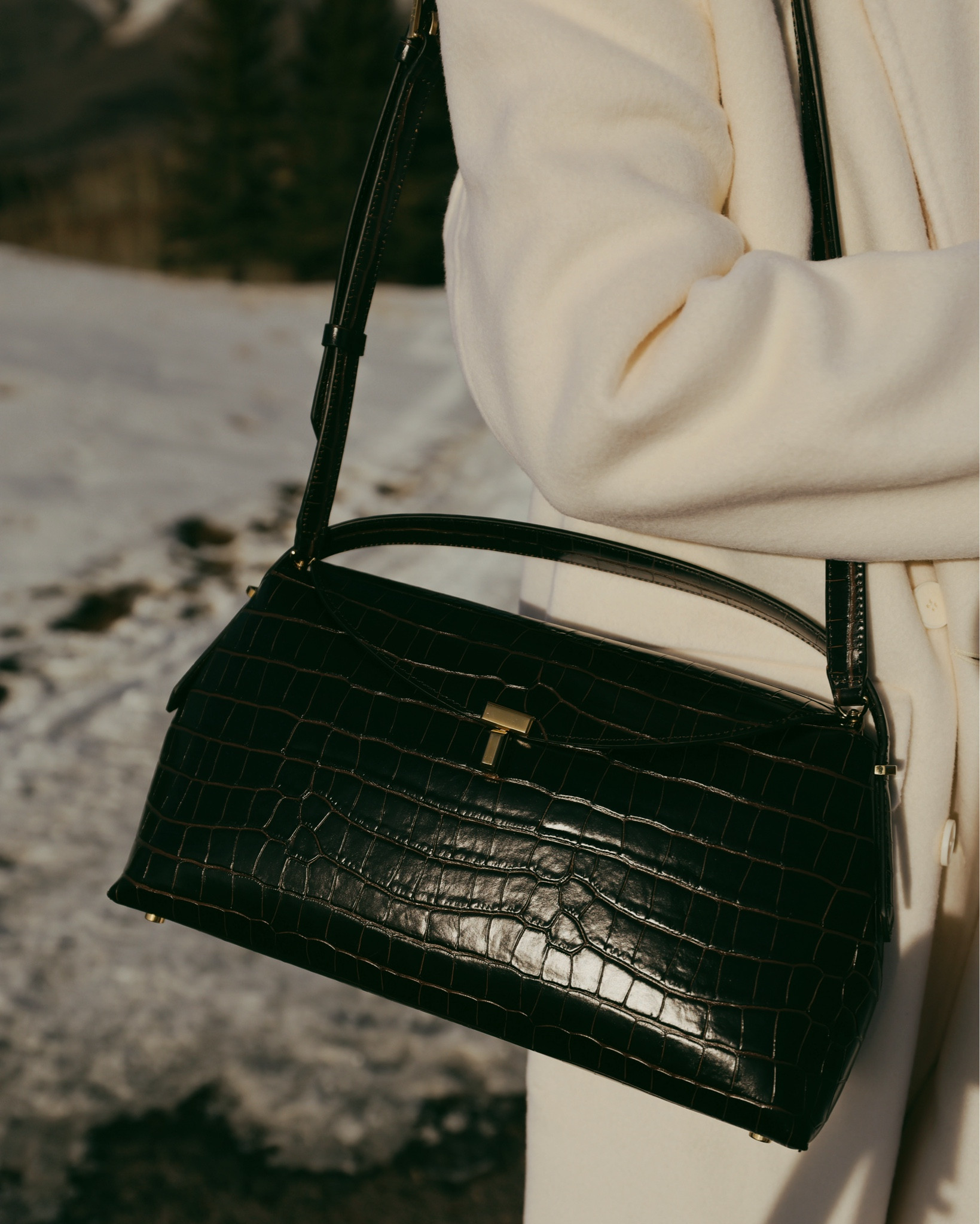 Your bag is often just a grab-and-go piece as you head out the door. But it’s an important detail that really can make the look. The right handbag adds structure, texture, and that final layer of polish that pulls everything together.

This gorgeous Toteme T-Lock bag  combines two major winter trends—deep chocolate tones and croc embossing—but in a way that still feels timeless and refined. The silhouette is structured, the hardware is minimal and elegant, and it’s surprisingly roomy. You can carry it on your shoulder or by the top handle, depending on your preference.

Think of your handbag as the final touch that truly completes the outfit.

