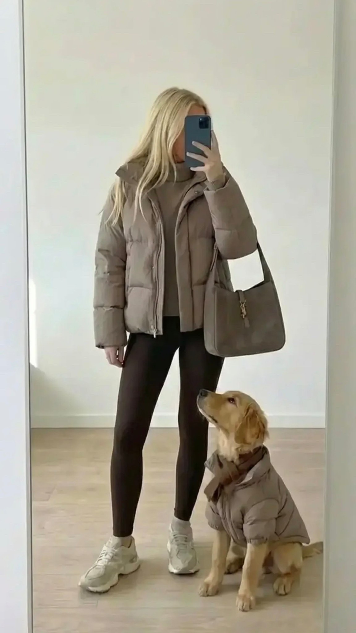 Minimal neutral mirror selfie / blonde woman wearing taupe puffer jacket over matching sweater / black leggings / white sneakers / structured taupe handbag / golden retriever wearing matching puffer jacket sitting beside her / soft natural lighting / clean minimalist room / cozy winter athleisure aesthetic / neutral tones / lifestyle fashion moment / candid influencer style

Description (30 words with /)
Neutral winter athleisure / cozy taupe puffer jacket / black leggings and crisp white sneakers / minimal mirror selfie / golden retriever in matching jacket / soft aesthetic / effortless everyday style / calm luxury vibe

Hashtags
#NeutralStyle #WinterAthleisure #MinimalStyle #CozyOutfit #PufferJacketSeason #AthleisureLook #NeutralAesthetic #StreetStyleDaily #CasualChic #EverydayStyle #CleanGirlStyle #MinimalFashion #NeutralOutfit #LifestyleAesthetic #WinterStyleInspo #DogMomStyle #GoldenRetrieverLove #MirrorSelfieStyle #EffortlessFashion #CozyVibesOnly

#LTKSpringSale #LTKFestival #LTKdayinmylife