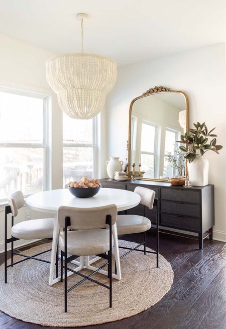 Our neutral breakfast nook features a wood bead chandelier, round white dining table, leather dining chairs, round jute rug, black cane sideboard and gold Primrose mirror. The windows are curtainless to allow for as much light as possible with the Alabaster wall paint. home decor dining room decor faux magnolia white stoneware vase

#LTKhome #LTKstyletip #LTKfamily