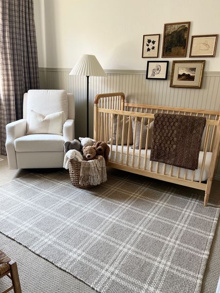 Neutral nursery styling 

Neutral spindle crib light natural wood upholstered glider white fabric check plaid throw pillow cover dark beige kilim stripe tan ivory pillow cover brown kantha quilt vintage framed art landscape vintage city brown rug Jellycat stuffed bunny doggy plaid drapery curtains vintage aged brass rocking horse arched mirror vintage childs chair iron floor lamp small faux tree pleated lamp shade floral black fabric kids woven rush seat chair vintage brass horse 

#LTKhome #LTKFind #LTKstyletip