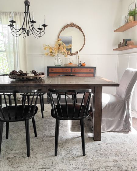 Dining room decor.  Dining room table.  Black modern dining chairs.  World Market table.  Loloi 7 x 10 area rug.  Slipcovered dining chairs.  Black chandelier.  Gold gilded vintage mirror.  

#LTKSeasonal #LTKhome