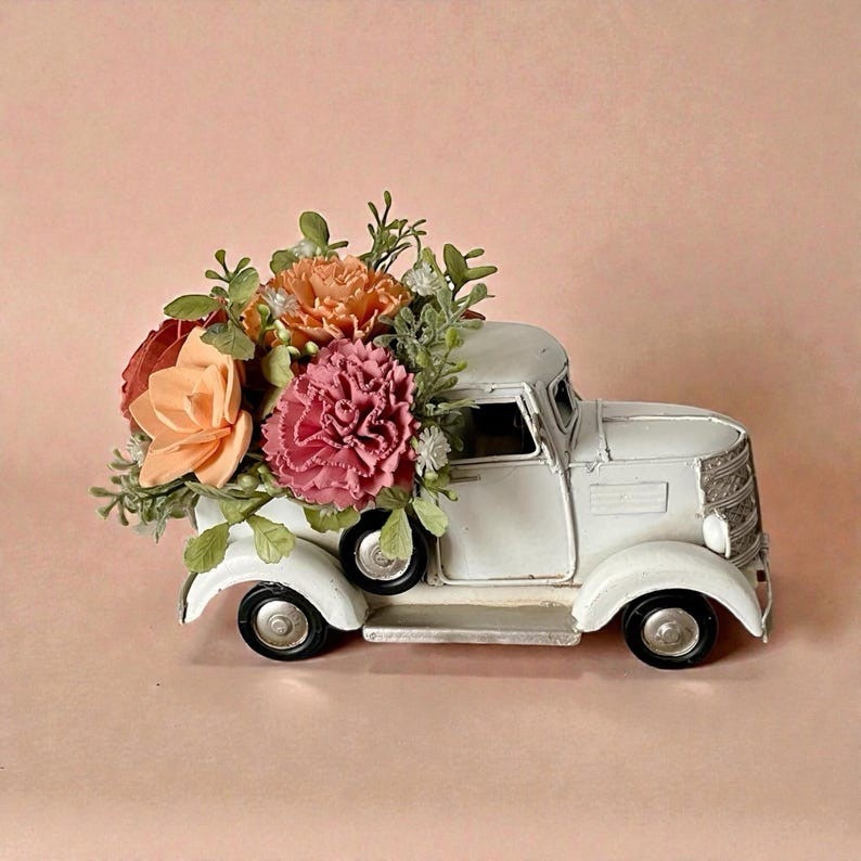 This adorable decorative truck filled with sola wood flowers adds a sweet farmhouse touch to any space. Each bloom is handcrafted from the root of the tapioca plant, then carefully dyed, fluffed, and arranged for a natural look that lasts forever. Measuring about 7” long and 5” tall, it’s the perfect little accent for a shelf, entry table, or seasonal display—and a thoughtful gift to brighten someone’s day. #LTKhome #farmhousedecor #solawoodflowers #rusticdecor #floraldecor #giftideas #homedecor #neutraldecor #handmadehome #cozyhome

#LTKHome #LTKWedding #LTKSeasonal