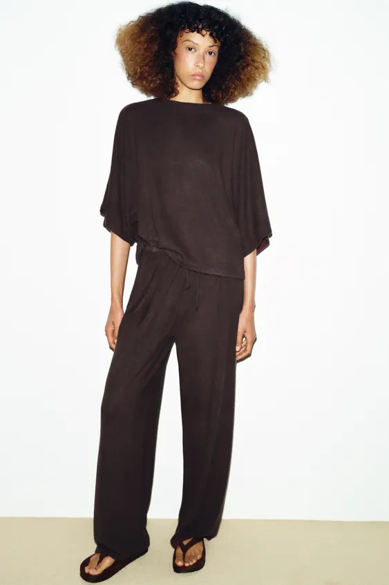 Trousers made from rustic fabric. Featuring a high-waist and elasticated waistband with a wide-le... | Zara UK