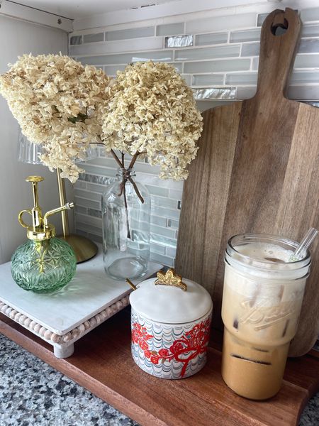 My coffee corner (all found on Amazon)
Dried white flowers, homemade latte, chinoiserie sugar jar, green glass plant spray and wooden risers and cutting boards. 

#LTKfindsunder100 #LTKsalealert #LTKhome