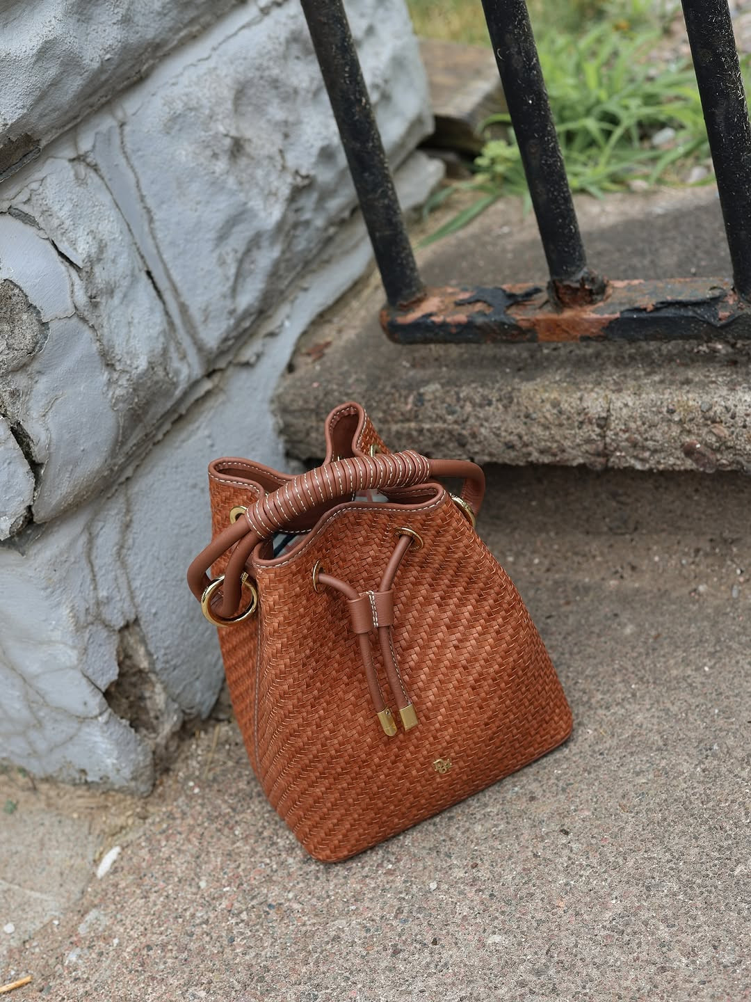Artisan appeal. This textured cognac bucket bag features a beautiful woven design, gold hardware accents, and a uniquely wrapped handle for the perfect neutral statement. #BucketBag #NeutralAesthetic #LTKaccessories 

 #LTKdayinmylife #LTKgrwm #LTKootd