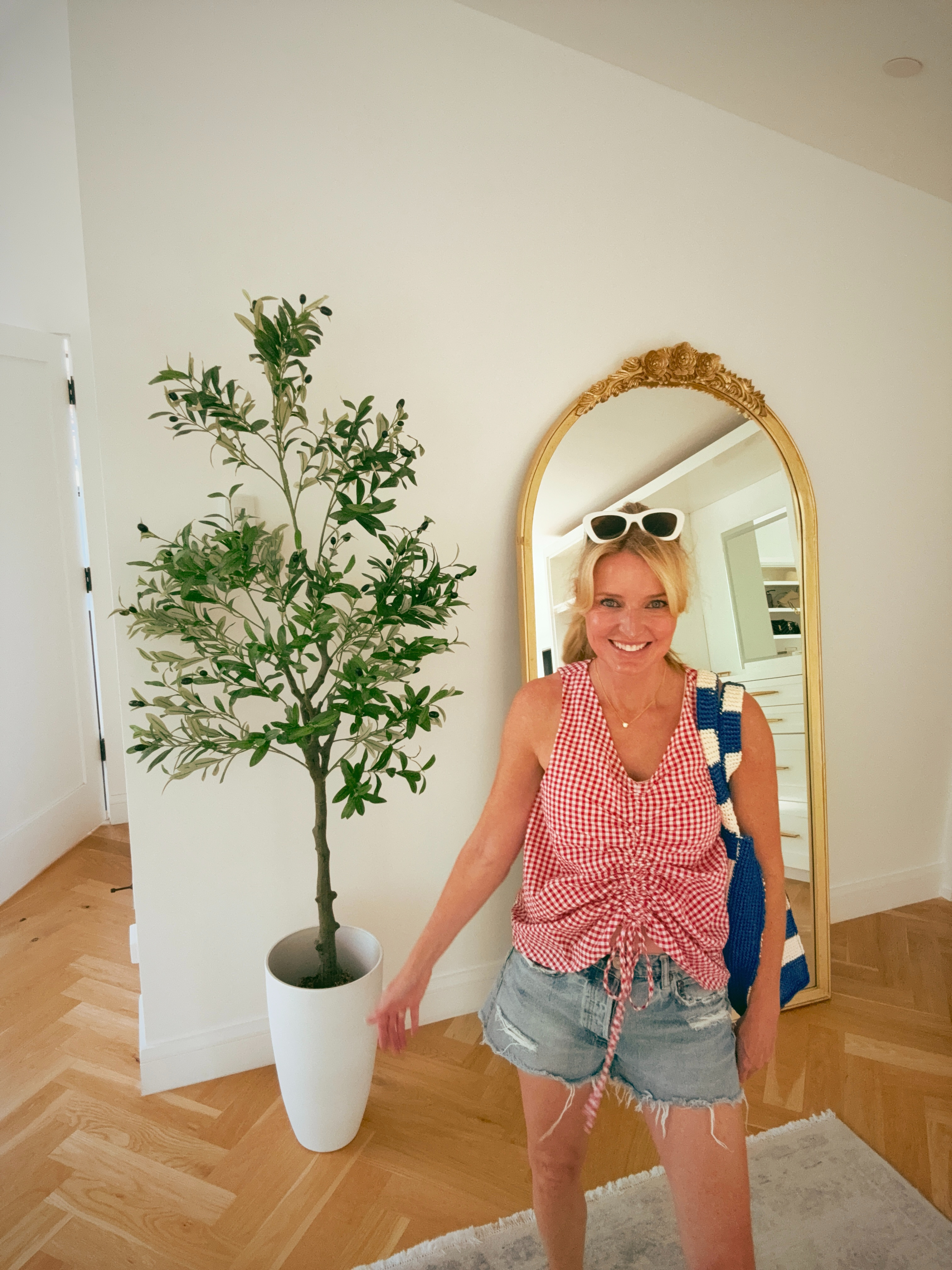 Red gingham, distressed denim cutoffs, white sunglasses; this combo never gets old! 

The Le Bop ruched front top is the piece that elevates it from basic to intentional. Great length, great fit, and that Loeffler Randall striped raffia tote pulls the whole color story together. 

 #LTKgrwm #LTKootd #LTKOver40