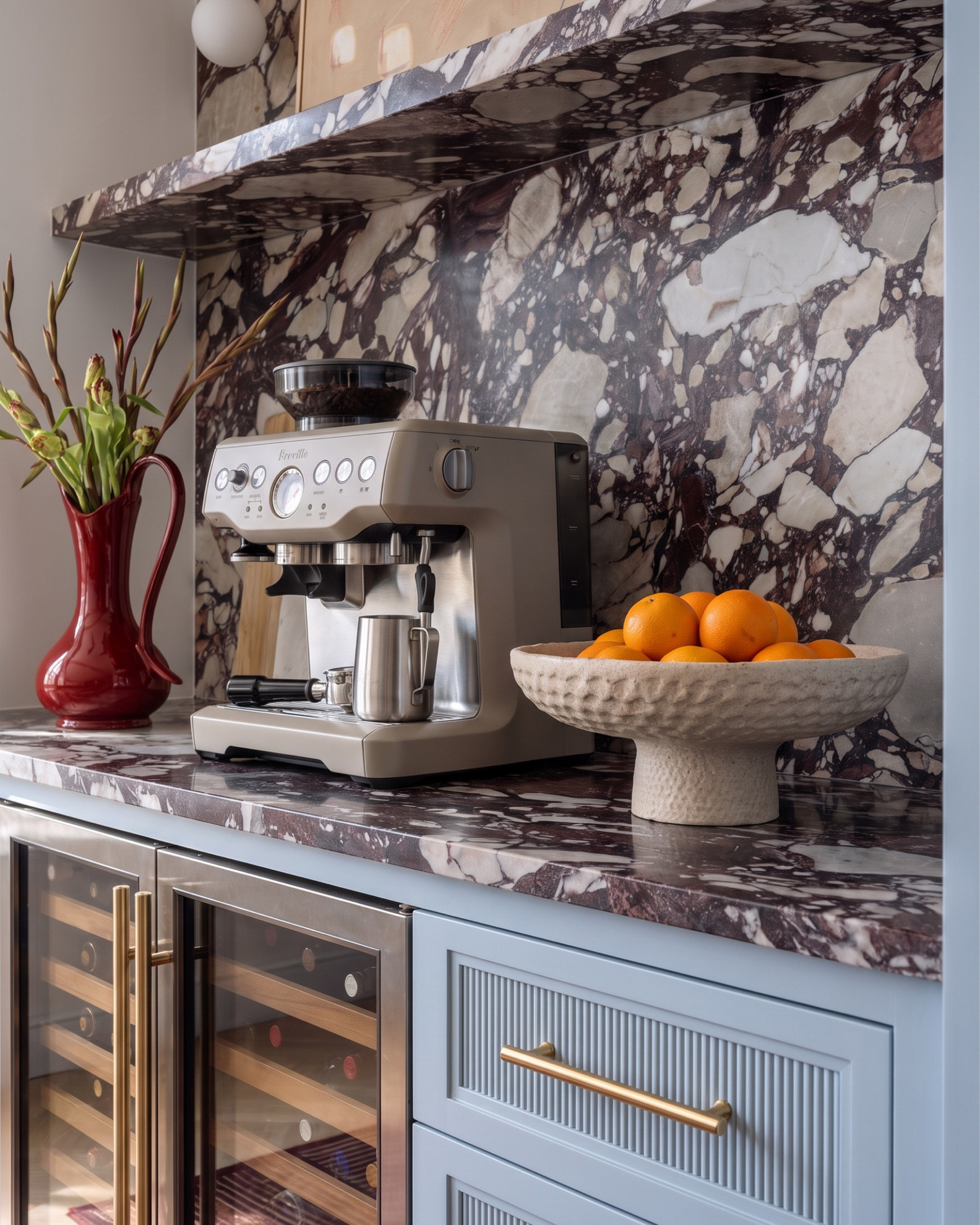 Shop the Look:
* Purple and cream stone slab backsplash
* Fluted powder blue cabinetry
* Brass bar pull hardware
* Dual zone wine and beverage fridge
* Built-in glass front cabinet
* White globe wall sconce (double)
* Abstract framed art print
* Red glass pitcher vase
* Wood cutting board set
* Breville espresso machine
* Hammered ceramic pedestal fruit bowl
* Striped runner rug
* Live edge wood console table
* Brass double globe wall sconce
* Abstract blue and red framed art
* Cranberry glass vase
* Marble table lamp
* Ceramic bust figurine
* Chunky knit jute pouf
* Blue and cream striped runner rug
* Framed abstract textile art
* Wood beam ceiling
* Marble top dining table
* Curved linen dining chairs (barrel back)
* Blue and white chinoiserie vase
* Wood frame china cabinet
* Textured red framed wall art
* Blue abstract vase
* Cluster globe pendant light
* Whitewashed wood sideboard
* Blue abstract shape framed art
* Ceramic textured floor vase
* Carved ceramic table lamp
* Brass shallow catchall bowl
* Vintage medallion area rug
* Antique wood buffet cabinet
* Gold hardware cabinet pull

#LTKsale #LTKhome #LTKstyletip
