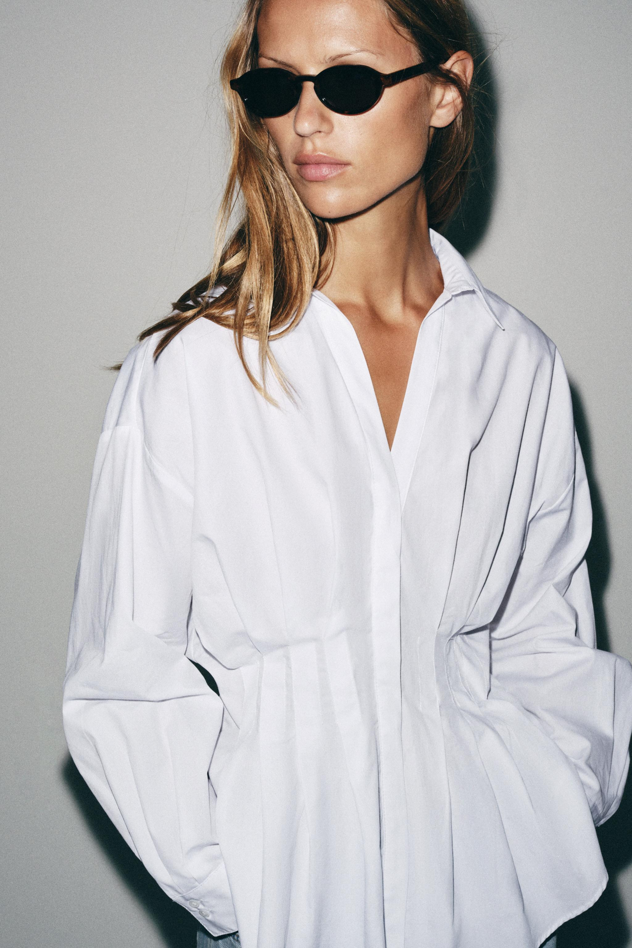 Shirt with a lapel collar, V-neckline, and long sleeves. Pleat detail at the waist. Front closure... | Zara US