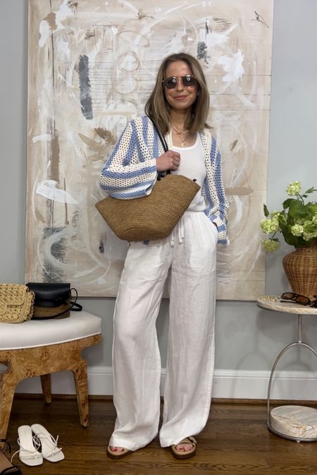 White linen pants vacation style
Splendid white linen pants KELLY20 to save
Striped open knit cardigan and other stories sold out. Linked similar styles but haven’t found a color/striped one 
Vehla sunglasses
Sezane sandals and tote bag 

#LTKstyletip #LTKtravel