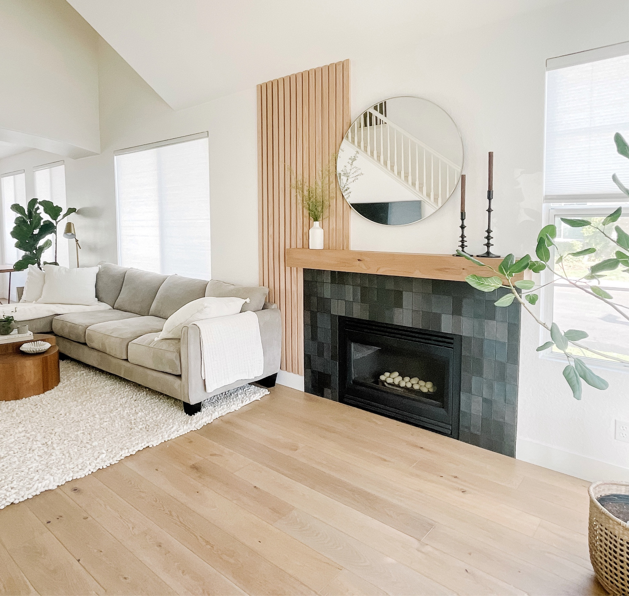 Asymmetrical fireplace wall feature with zellige tile, rustic mantle, wooden slats, round mirror and mantle decor. 

#LTKunder100 #LTKhome