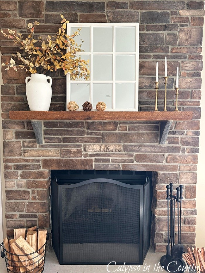 Fall decor for your fireplace mantel.  Simple faux fall foliage stems in a white vase makes an impact next to a white window pane mirror and woven orbs.  A classic black fireplace screen gets you ready for a fire on a cozy fall evening.

#LTKSeasonal #LTKHome