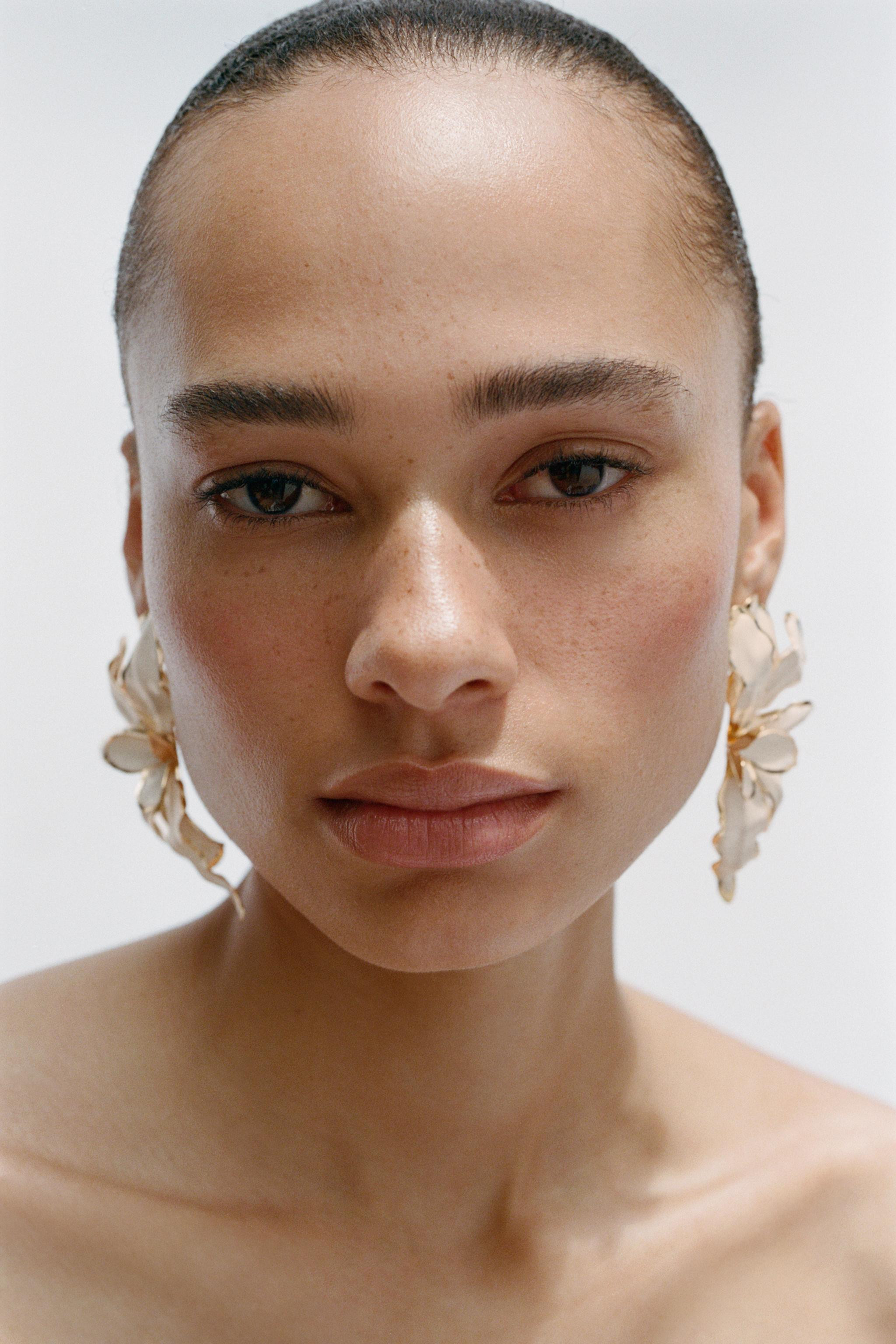 Coloured metal earrings with a raised flower design. Butterfly clip closure. | Zara DE