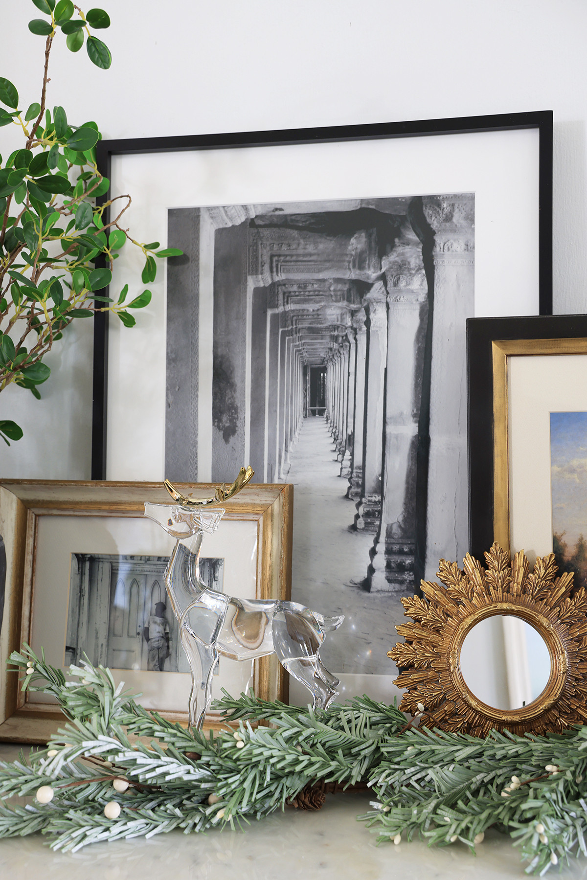 Simple Christmas holiday vignette with an acrylic deer with gold antlers, mistletoe garland, and art or mirrors 

 #LTKHoliday #LTKSeasonal #LTKHome