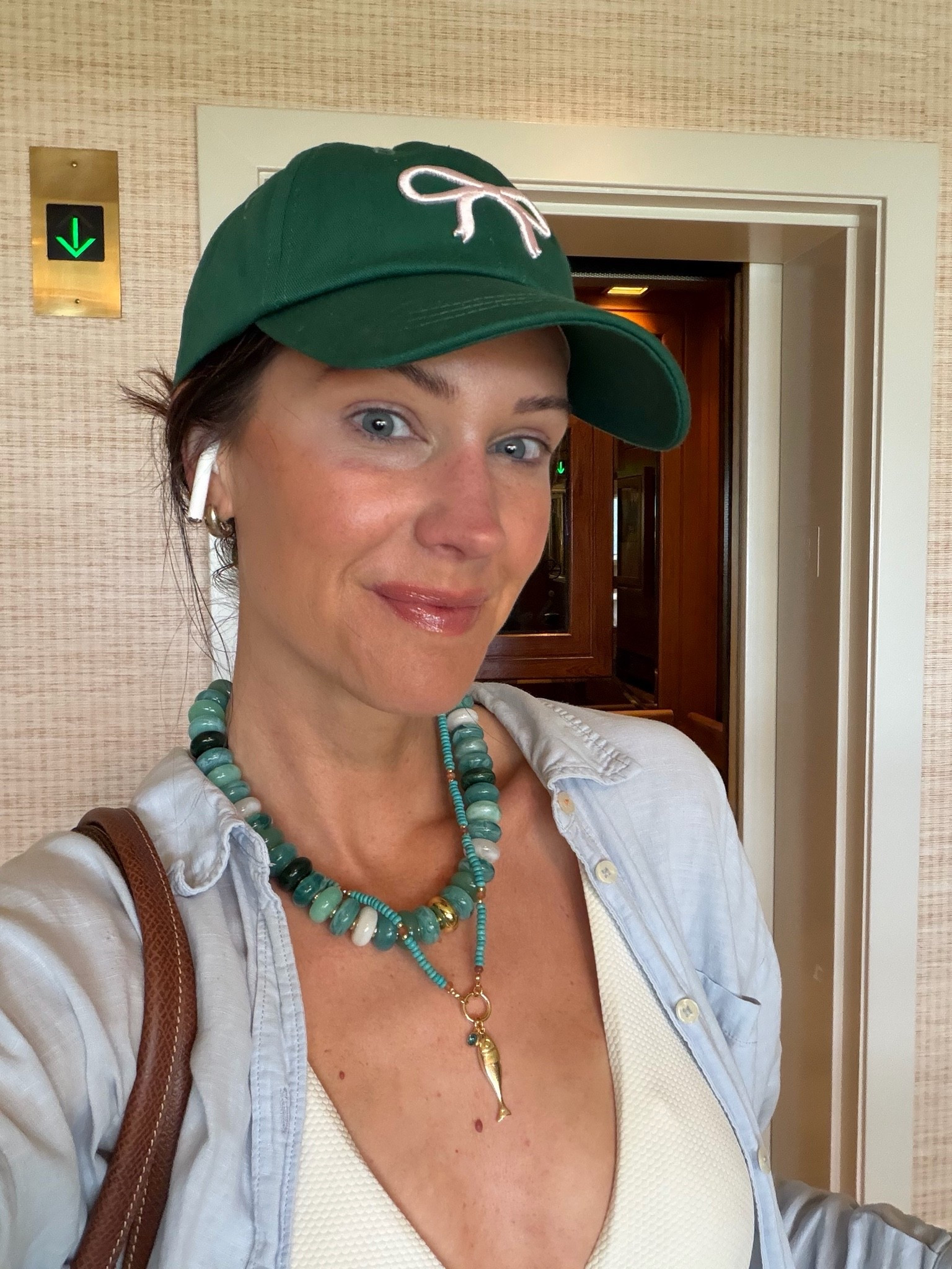 Mom outfit but make it chic with chunky beaded necklaces and a baseball hat to match.