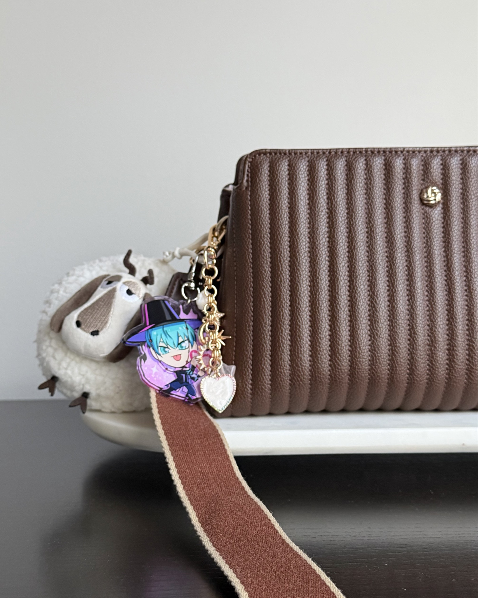 Added another bag charm to my everyday crossbody ✨ I love the heart and star charms and some of them are made with pearl and rose quartz. Layered this bag charm with two charms I already have, the first is a sheep pouch charm I got from How to Train Your Dragon - Isle of Berk at Epic Universe and the second is a Baby Saja charm my friend gifted me, a fun personalized mix. Also, if you like a wide purse strap, this is one I purchased separately and comes in a ton of colors! My crossbody came with a thin strap and I find wide bag straps to be more comfortable and switched out the one this purse came with to this other one I purchased. So worth the purchase! It’ll go with some of my other purses too!

#LTKdayinmylife #LTKHome