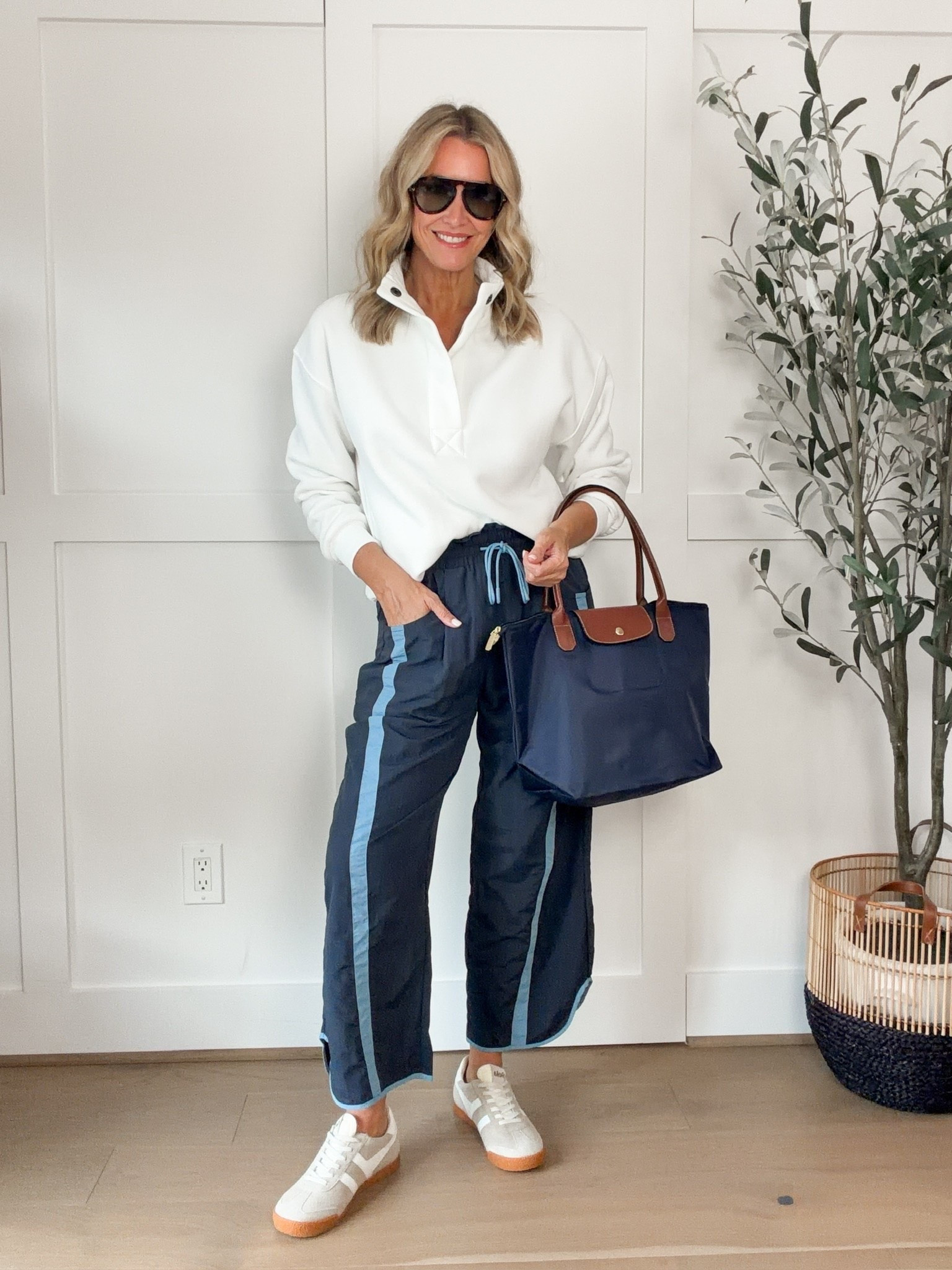 These navy track pants are such a fun way to change up a casual outfit! I love the light blue side stripes and relaxed wide leg shape, especially paired with a simple white pullover and neutral sneakers. Add a roomy navy tote, and you have a comfortable outfit that works for travel, errands, or a busy day out.
navy track pants, wide leg track pants, striped track pants, navy and white outfit, white pullover, casual fall outfit, sporty casual style, athleisure outfit, travel outfit ideas, sneakers outfit, comfortable everyday outfits, women over 40 fashion, HauteandHumid