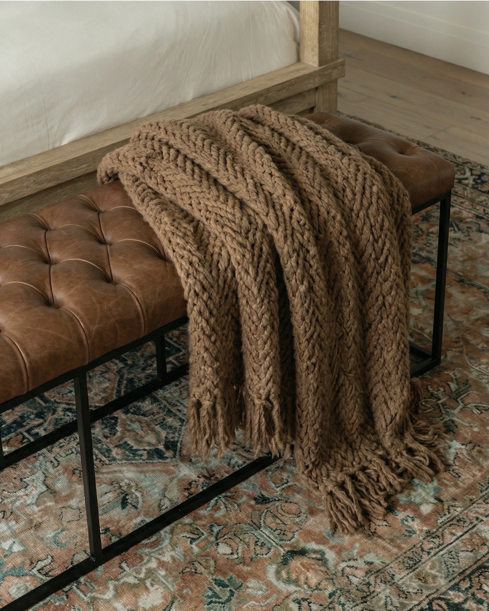 Shop the look:
* Wood canopy bed 
* Brown leather upholstered bench
* Brown knitted blanket
* Brown throw pillows
* Brown wood 3 drawer nightstands
* Wall art
* Glove wall lights
* White tree planter
* Black vase
* Black table lamp
* White decor bowl
* Decor books
* Wood dresser
* Brown traditional rug 
* Wood decor beads
* Wood upholstered swivel chair
* Wood end table
* Green runner rug 
* Faux olive tree

#LTKsale #LTKhome #LTKstyletip