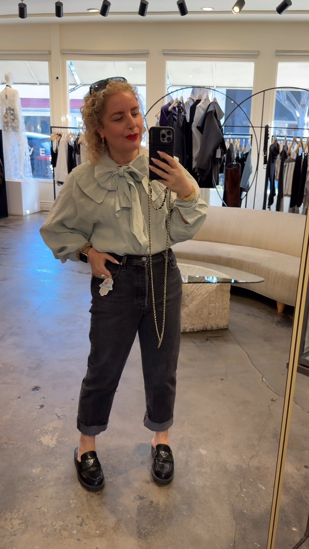 Modern Parisian meets LA ease. Romantic bow-tie blouse balanced with relaxed, cuffed straight-leg jeans. Prada slides on repeat because polished flats are very now. The hamsa keychain casually doubles as a jean charm (personal details > trends). Bandolier phone case = new wallet + purse, hands-free and chic.

Style tips:
• Let the blouse be the statement keep jewelry minimal
• Cuff jeans to show ankle + shoe hardware
• Treat keychains like accessories, not extras

Fit notes:
• Blouse true to size (size up for extra volume)
• Jeans fit the waist first, relaxed through the leg
• Slides run true to size

Effortless, intentional, and very current.

#LTKWorkwear #LTKootd #LTKPetite