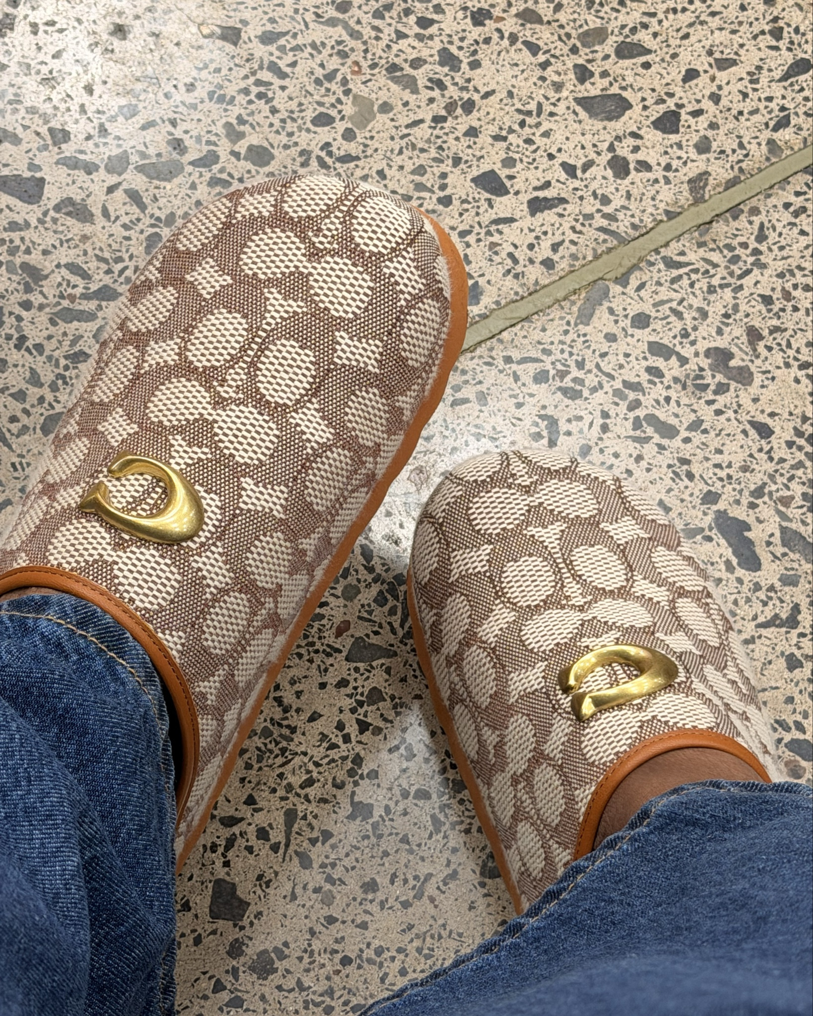 C. O. A. C. H. 

These Coach slides are the most stylish and comfortable shoes to have. Ive gotten so many compliments.  These are definitely a must have!