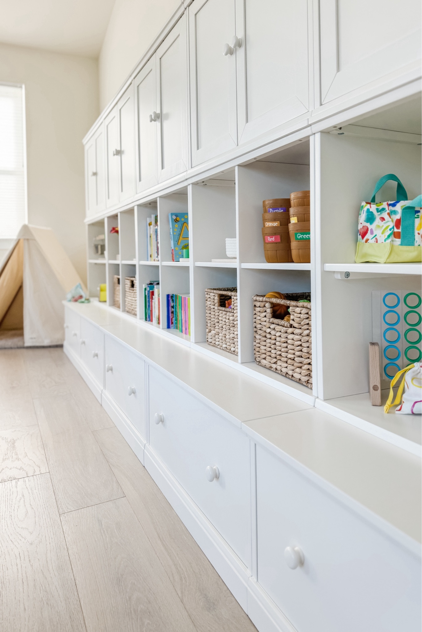 Our playroom storage is a dream! I have been trying to find a solution that worked for organization, easy play access, as well as storage for toy rotation; this setup is exactly what I was looking for! In addition to how functional it is I appreciate how beautifully it fits into our playroom.

We have five total units: one three-piece set and then two more “build your own” units on either end to match (but with open shelves instead of cubbies).

#LTKKids #LTKHome #LTKFamily