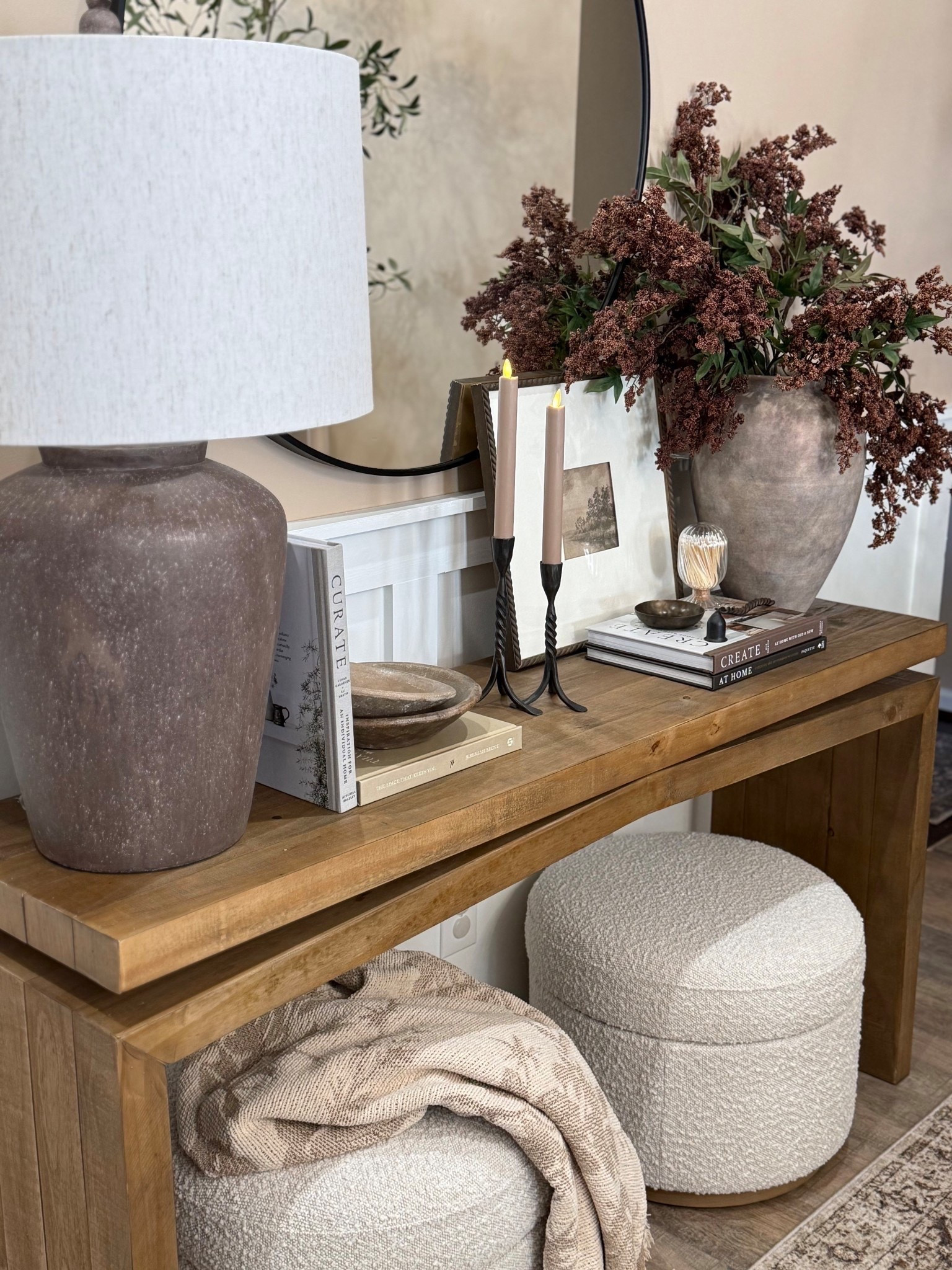 Console Table Views. Follow @farmtotablecreations on Instagram for more home finds and styling ideas 🤎

This layered console table setup instantly makes an entry feel warm, polished, and designer-done. I love mixing natural wood tones with soft textiles, ceramic finishes, and a touch of metal for contrast. The oversized textured lamp anchors the space, while stacked books, candle holders, and a statement vase with faux stems add height and interest without feeling busy. Tucked ottomans underneath keep it functional for extra seating while maintaining that clean, cozy look.



#consoletable #entrywaydecor #entrywaytable #tablelamp #ottoman #neutraldecor #homedecor #livingroomdecor #accentfurniture #homefinds

#LTKHome #LTKSaleAlert