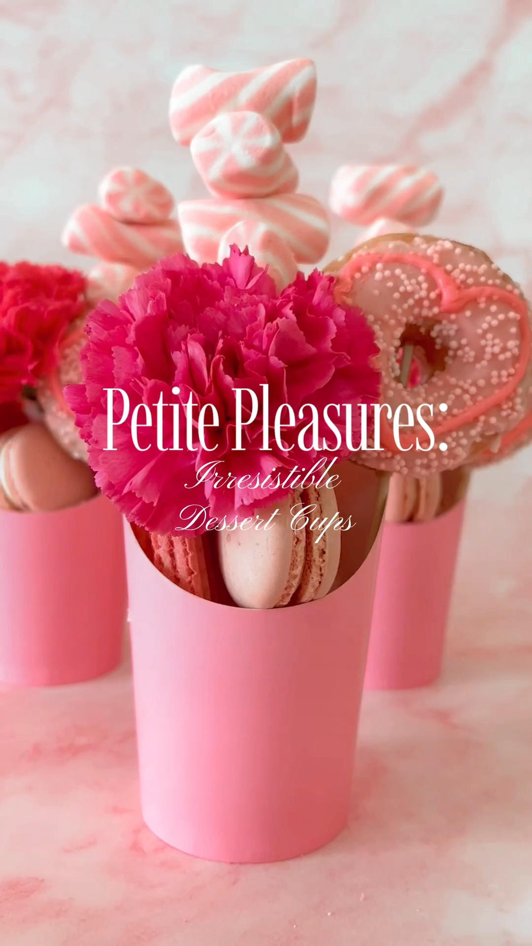 Ever marveled at the charcuterie cups stealing the show? Well, get ready for a delightful twist as we infuse the same flair into our desserts! Imagine adorable cups, brimming with sweet sensations, tailor-made for your summer soirees.
To keep things upright and oh-so-stylish, I've nestled a handful of chocolate- covered almonds and marshmallows at the cup's base – they’re the anchors that make the magic happen. These fluffy delights also pull double duty as the marshmallow skewer's launchpad.
Now, let's dive into the decadence within these cups. Delicate pink wafer cookies bring that irresistible crunch, while a dainty pink mini donut adds a playful touch. Ever-elegant French macarons join the party two by two, each bite a taste of pure sophistication.
But wait, there's more! A stunning hot pink flower crowns the creation, infusing a burst of color and charm that's hard to resist.
The best part? It's a swift, few-minutes affair to put together this jaw-dropping masterpiece! Ready to dive in? I've rounded up all the essentials so you can recreate this culinary marvel in a snap. Your summer bash is about to get an irresistible upgrade!🌸 