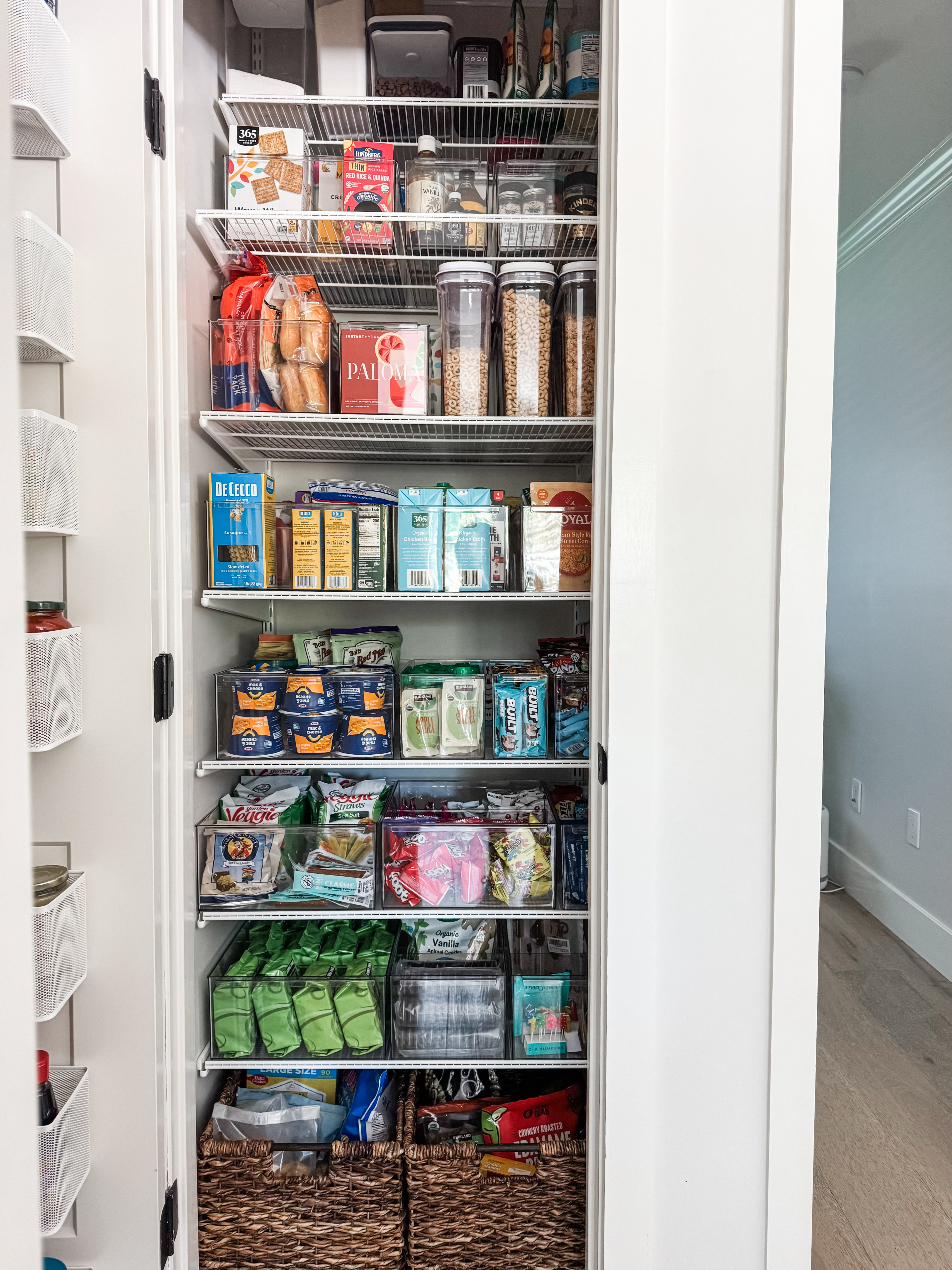 This small, coat- closet sized pantry was in need of more space. I added a door mounted Elfa system with baskets for the jars and cans. I also edited the shelf spacing and created simple categories with my favorite Everything Organizer bins from The Container Store. #smallspaceorganizing #smallspace 

 #LTKHome #LTKFamily