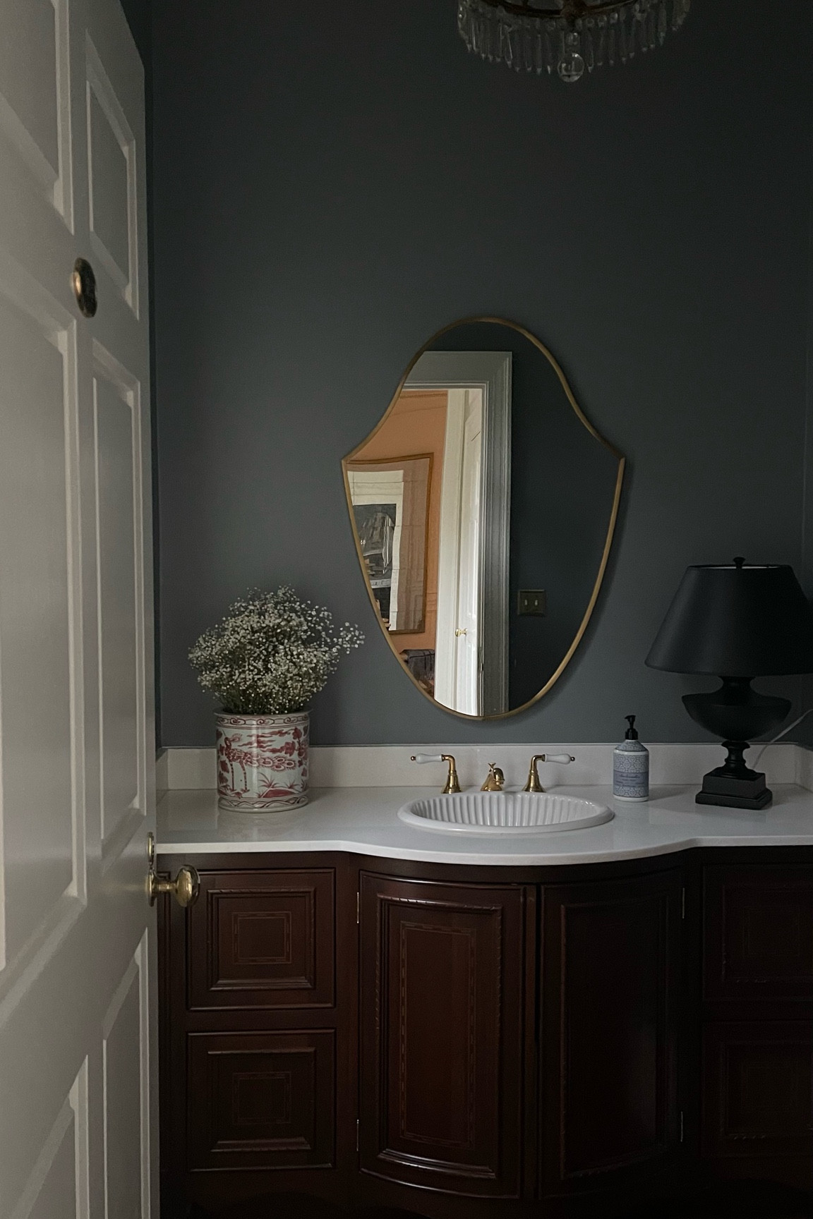 Powder bathroom design, red chinoiserie vase, brass crest mirror; shield mirror 

#LTKFind #LTKhome
