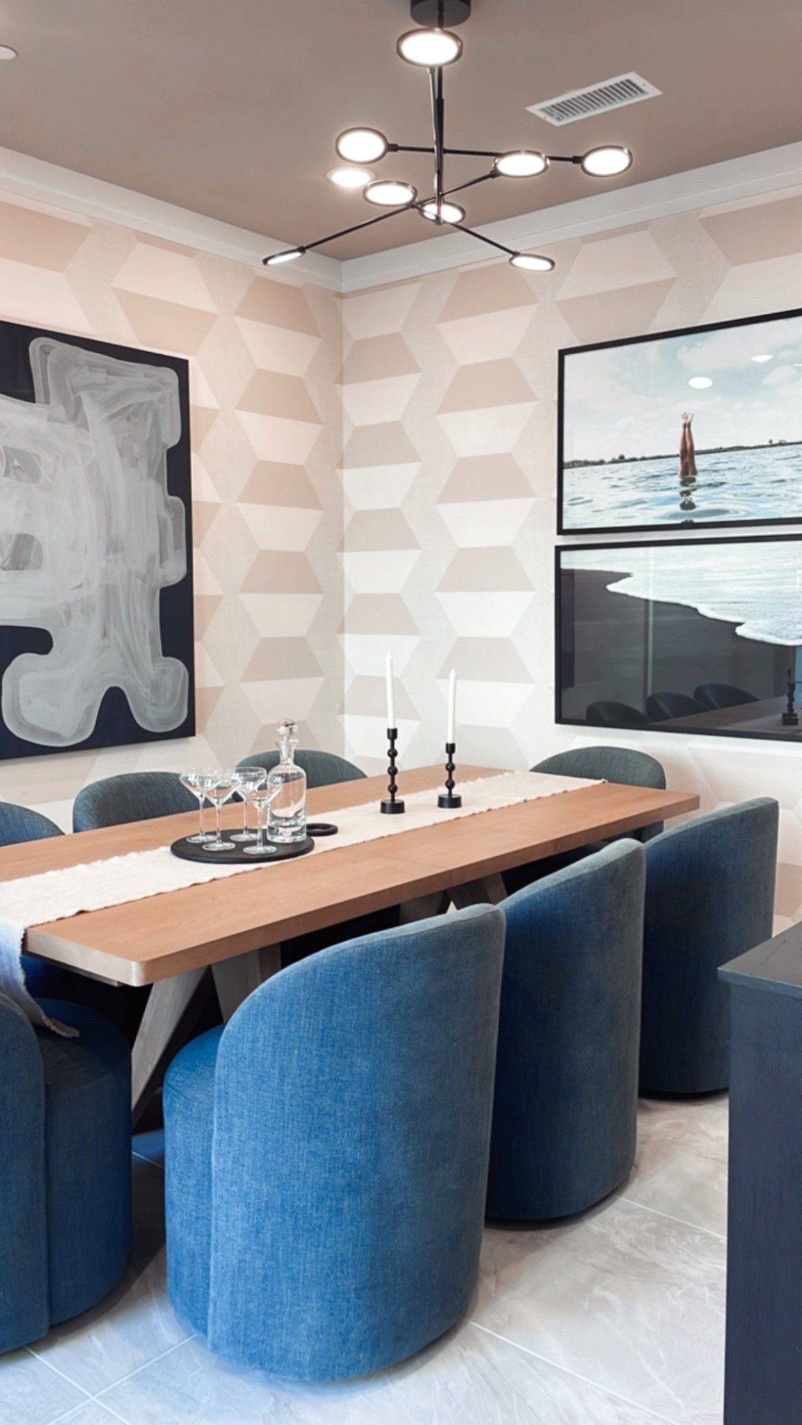 Dining room with extension dining table for 8 people, navy blue upholstered swivel chairs, geometric wallpaper and modern artwork. 

#LTKHome #LTKSaleAlert