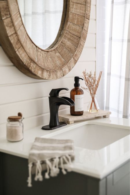 Bathroom accessories including a beautiful travertine footed tray, custom glass soap dispenser, and botanical reed diffuser

#LTKhome #LTKfindsunder50
