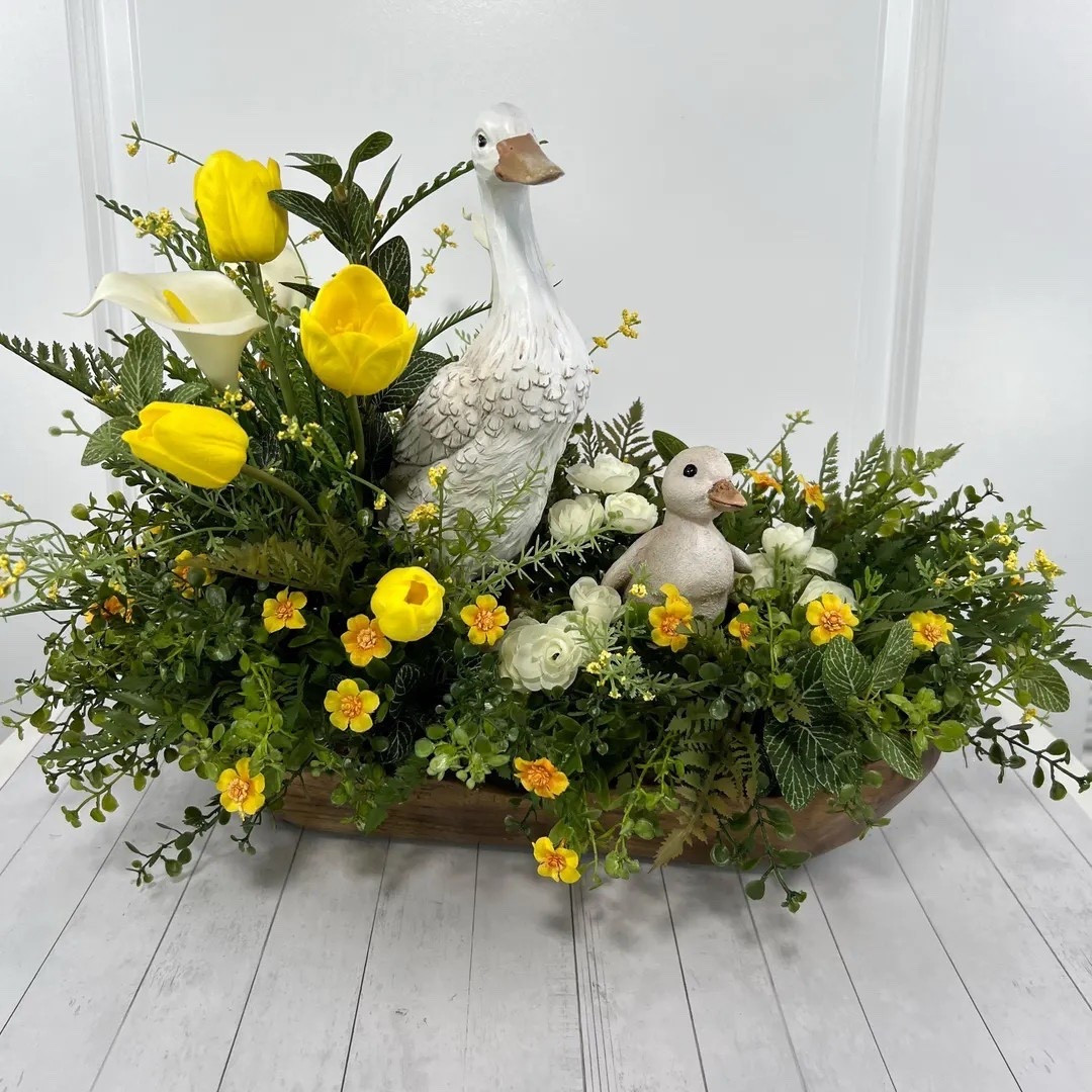 Welcome the sweetness of spring with this charming dough bowl centerpiece featuring a mama duck and her duckling nestled among bright yellow tulips, a graceful white calla lily, and lush greenery. Designed in a rustic wooden dough bowl, this arrangement blends cheerful florals with farmhouse charm to create a warm, garden-inspired display. Perfect for Easter tables, kitchen islands, entryways, or seasonal decor, it brings a playful yet elegant touch of springtime to any home. 🦆🌷🌿

#LTKHome #LTKSpring #EasterDecor #FarmhouseDecor #SpringCenterpiece #TulipDecor #DoughBowlDecor #SeasonalDecor #SpringHome #HomeDecorFinds

#LTKHome #LTKSeasonal #LTKSpringSale