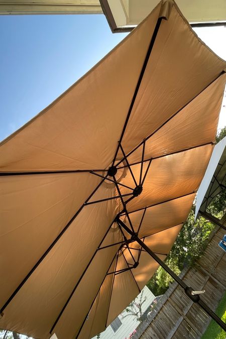 Shade in the backyard is a luxury in Texas. This extra large, 15 x 9’ patio umbrella does the trick! It’s a great value because it includes the base and is HUGE, like a triple sized market patio umbrella providing ample shade, even greater shade cover than the backyard pergola we previously built and 1000x faster and easier to put together. 

Simply anchor the base in a patio table- we used a hole cutter to put this through the middle of our picnic table. When not in use, simply wind it down and put a cover over it (optional). 

#LTKSeasonal #LTKhome