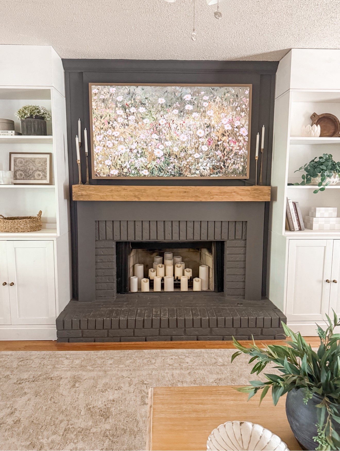 My fireplace area

(We have gas logs- I removed them for safety with little ones and a puppy)- and added these battery candles in its place- they add a warm glow year round. 

TV is the CanvasTv- has Art mode so ru  included art - best part- no wires or box to hide and an ultra matte finish. 

Fireplace color: BM IRON MOUNTAIN
Built-ins-Ikea Havsta (I built the top piece to close on the open top. 

Mantle is a DIY- full tutorial is on my blog: www.mydiyhappyhome.com 

#LTKStyleTip #LTKFindsUnder50 #LTKHome
