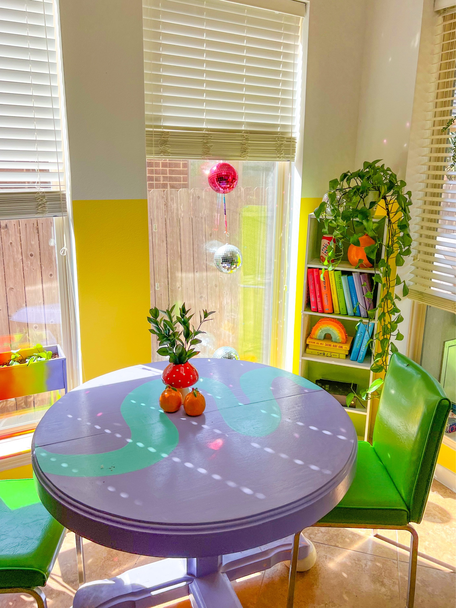 Rainbow details in the rainbow house 🌈💞 I loved painting this dining table to tie in more color- and the rainbow book shelf really pulls it all together!🤩 The perfect size for my book collection- plus, who doesn’t love cute vases on their dining table?🍄🌈💞
