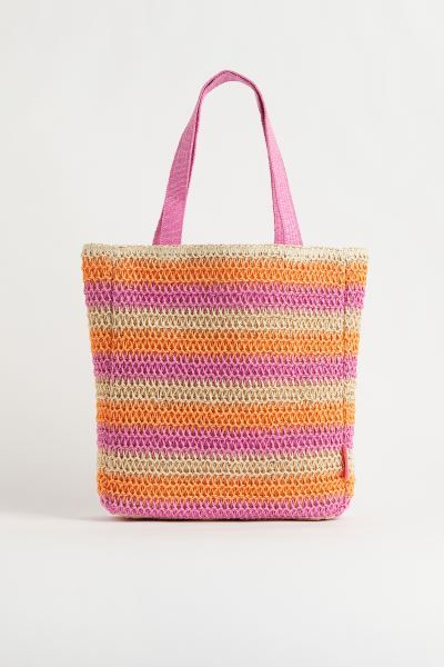 Lined, crochet-look bag in braided paper straw with two handles at top. Depth 4 in. Width 13 1/2 ... | H&M (US + CA)